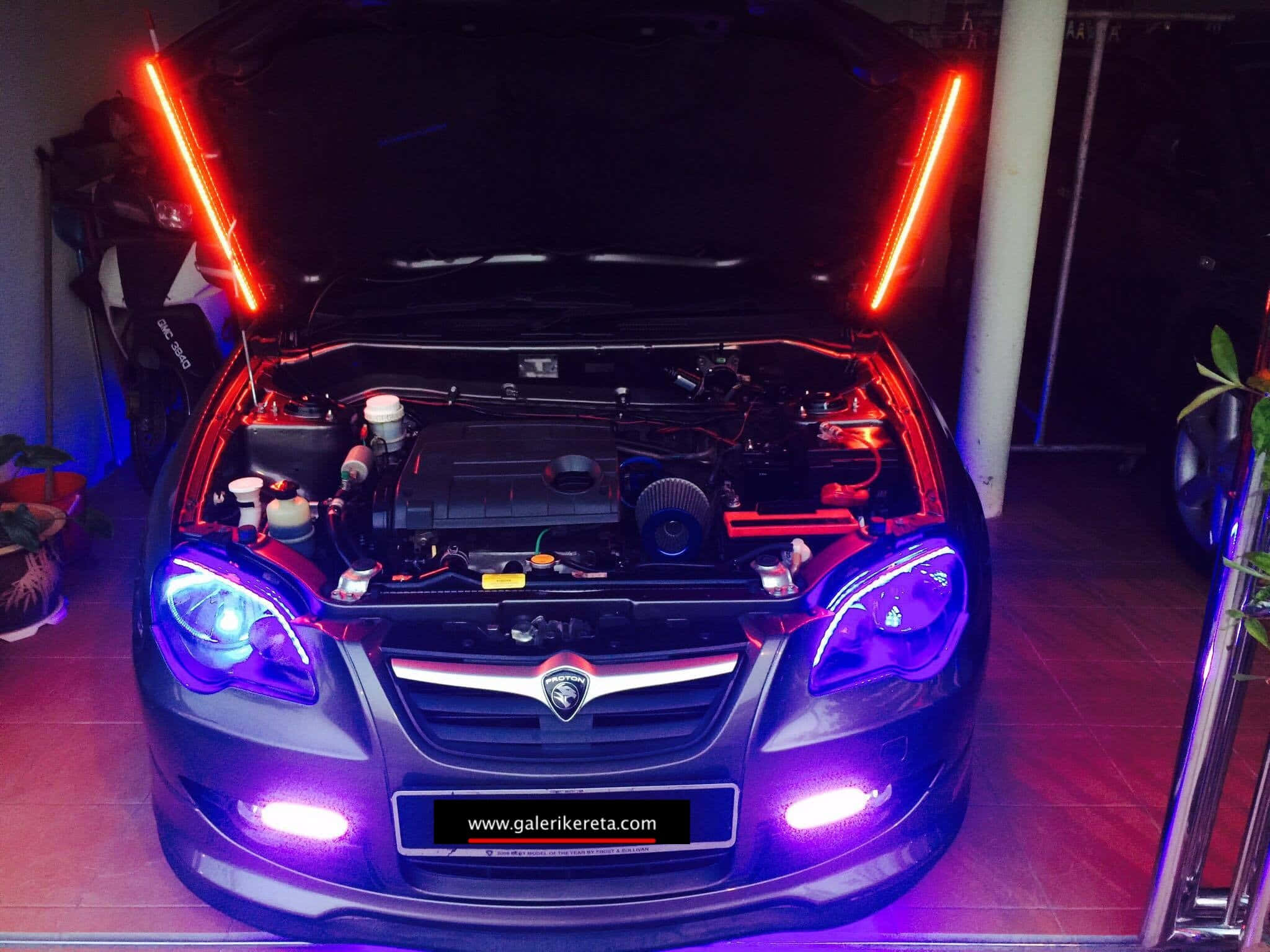 Proton 桌布 壁紙 — 一輛深色汽車打開引擎蓋，露出在昏暗車庫中由鮮豔紅色和紫色LED燈照亮的發光引擎室。