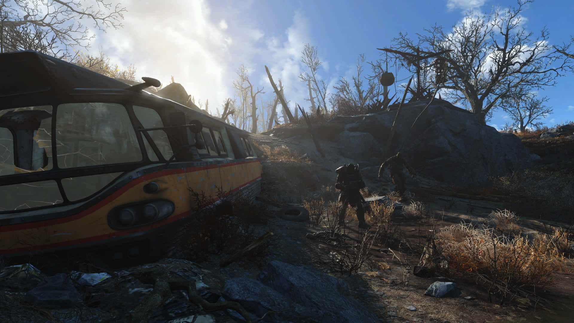 Fallout 4 Wasteland 桌布 壁紙 — 一輛生鏽的黃色巴士被遺棄在荒涼的廢土上，兩個身影在光禿的樹木和岩石地形中跋涉，頭頂是明亮的太陽。