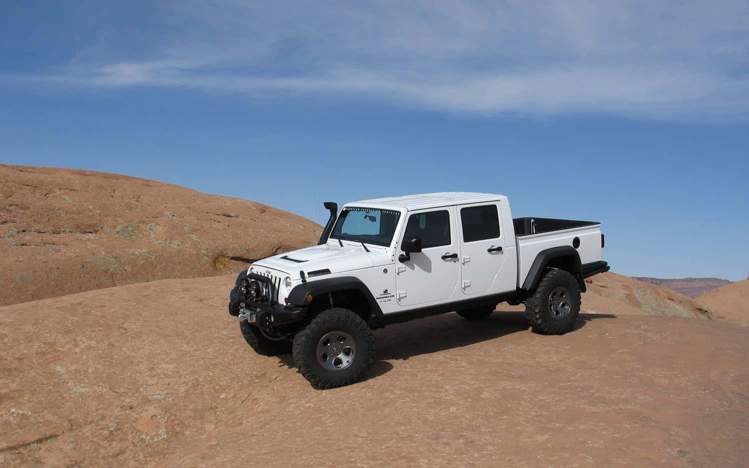 Jeep Gladiator 桌布 壁紙 — 一輛白色Jeep Wrangler pickup truck停泊在陽光普照的紅岩沙漠山脊上，背景是清澈的藍天。