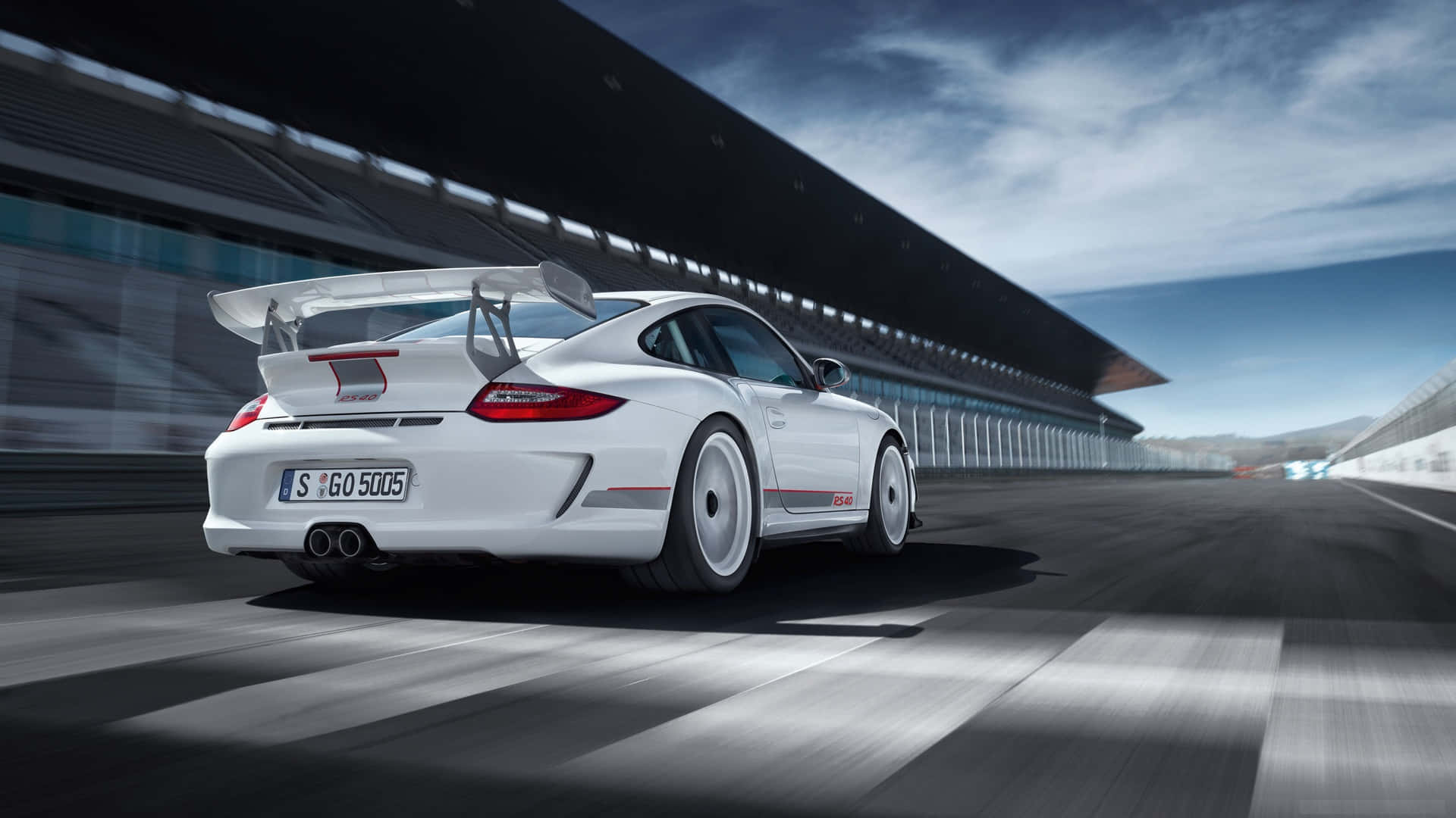 保時捷 桌布 壁紙 — 一輛白色保時捷911 GT3 RS在戲劇性的天空下沿著賽道飛馳，動態模糊強調了速度。