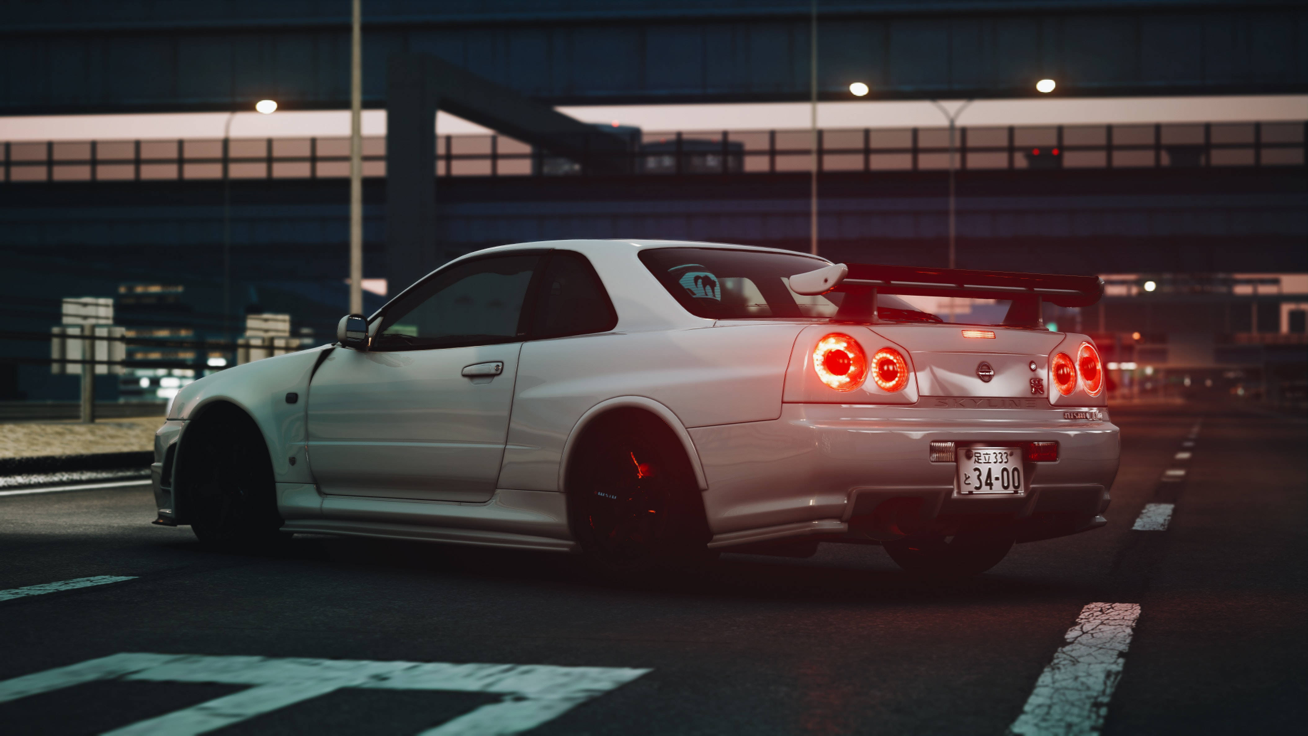 Nissan 桌布 壁紙 — 一輛白色日產Skyline R34跑車，紅色尾燈亮起，停泊在黃昏天橋下的城市街道上。