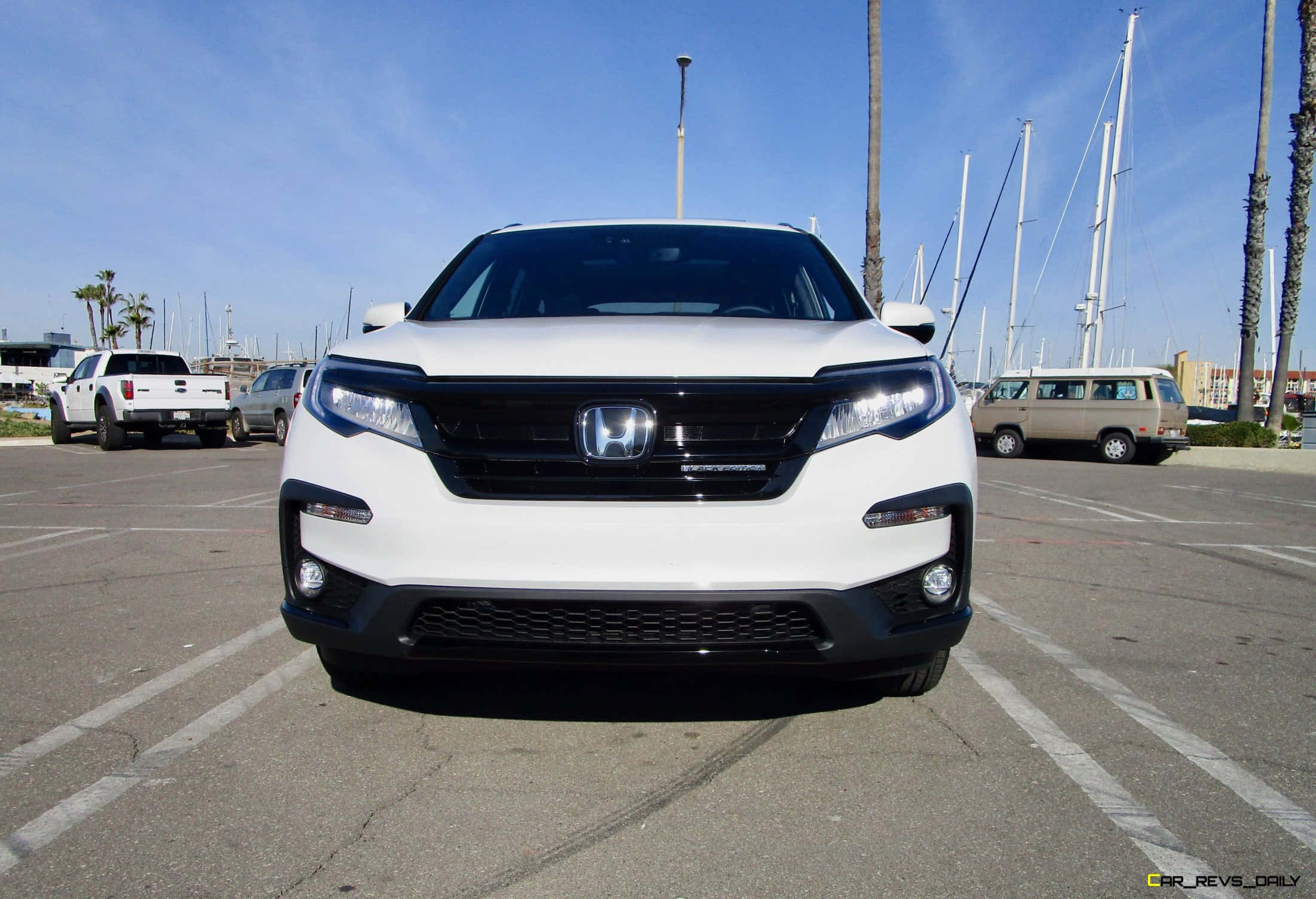 Honda Pilot 桌布 壁紙 — 一輛白色本田CR-V SUV正面朝前，停在陽光明媚的停車場，背景有帆船桅杆和棕櫚樹。