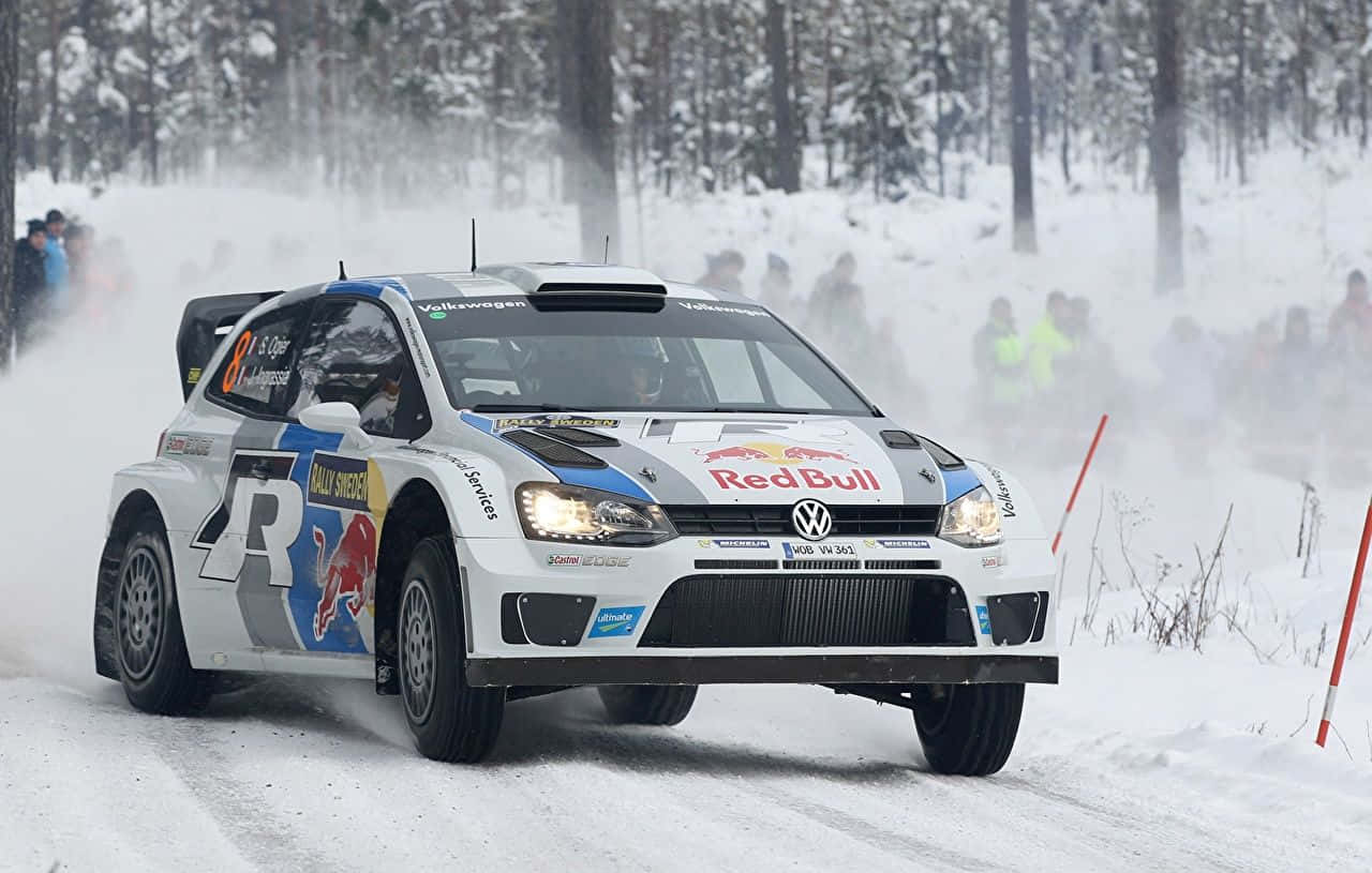 Ice Racing 桌布 壁紙 — 一輛白色福士偉根拉力賽車帶有紅牛塗裝，在雪地森林賽道上疾馳，揚起雪霧。