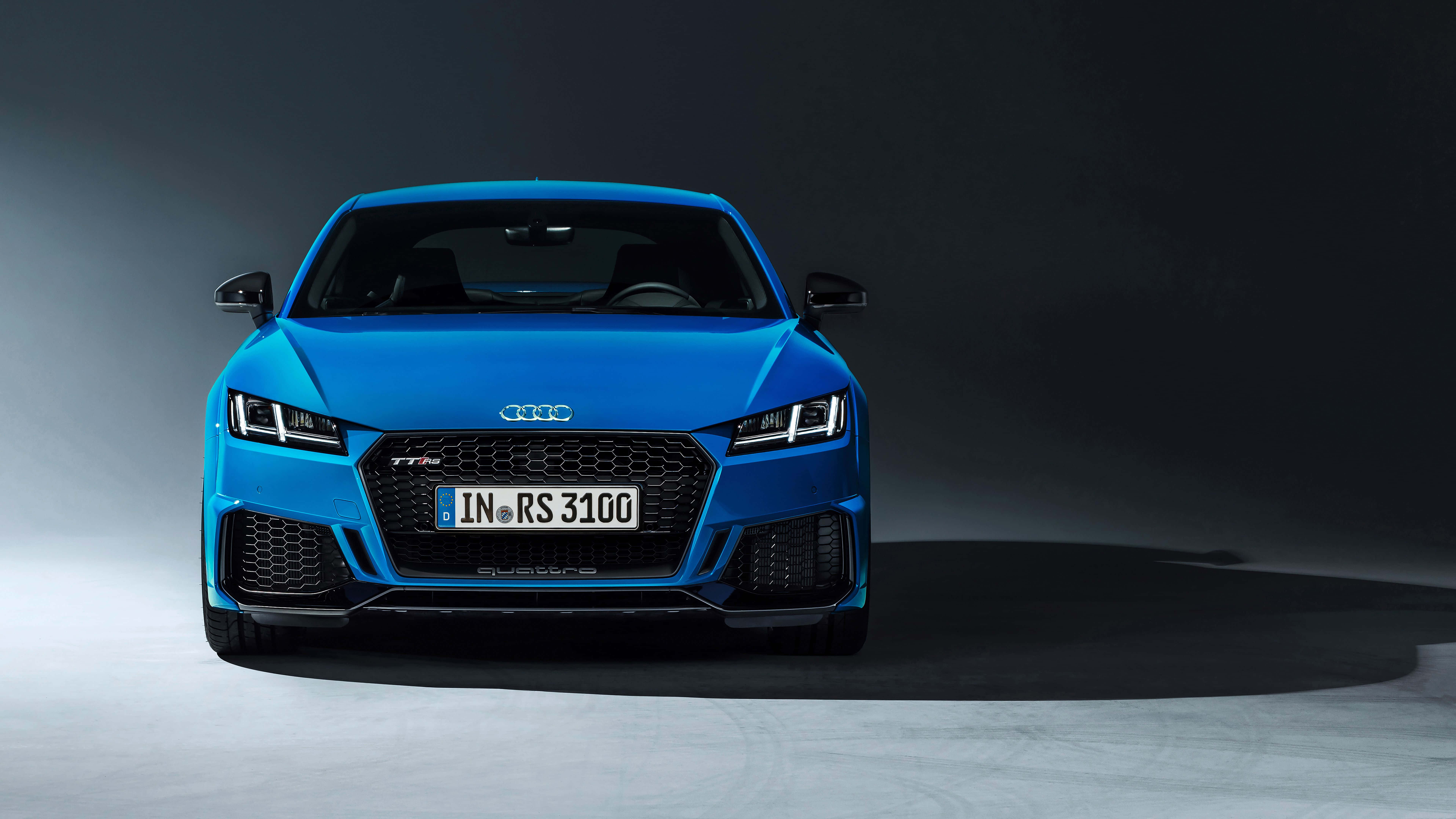 一輛紅色 Audi TT 運動跑車於壯麗戶外景觀中 壁紙 — 一輛充滿活力的藍色奧迪TT RS 3100跑車在極簡風格的工作室中，以戲劇性的燈光和深色背景正面朝前。