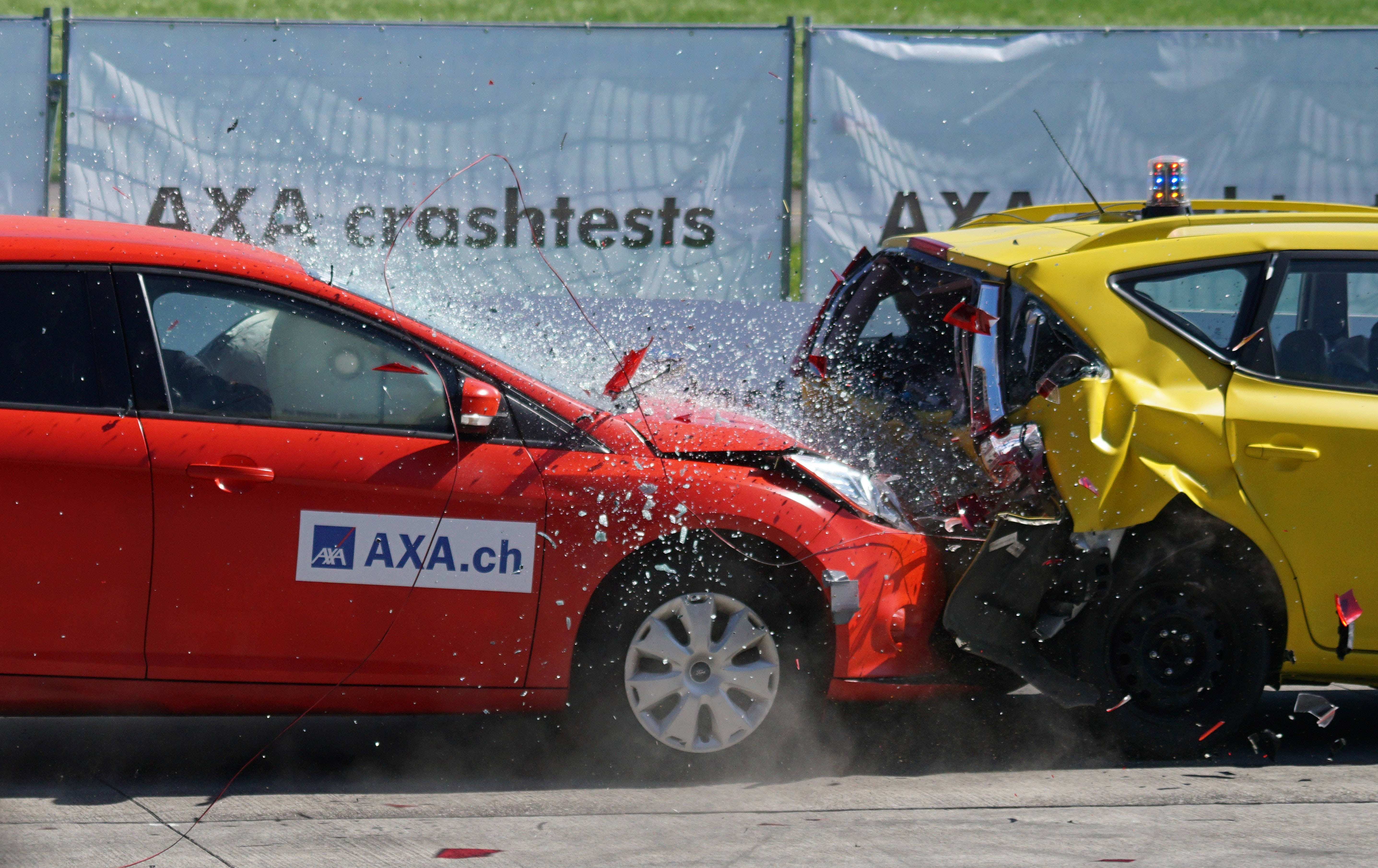 Car Accident 桌布 壁紙 — 一輛紅色和黃色汽車在受控碰撞測試中猛烈相撞，碎片飛揚，塵土飛揚。