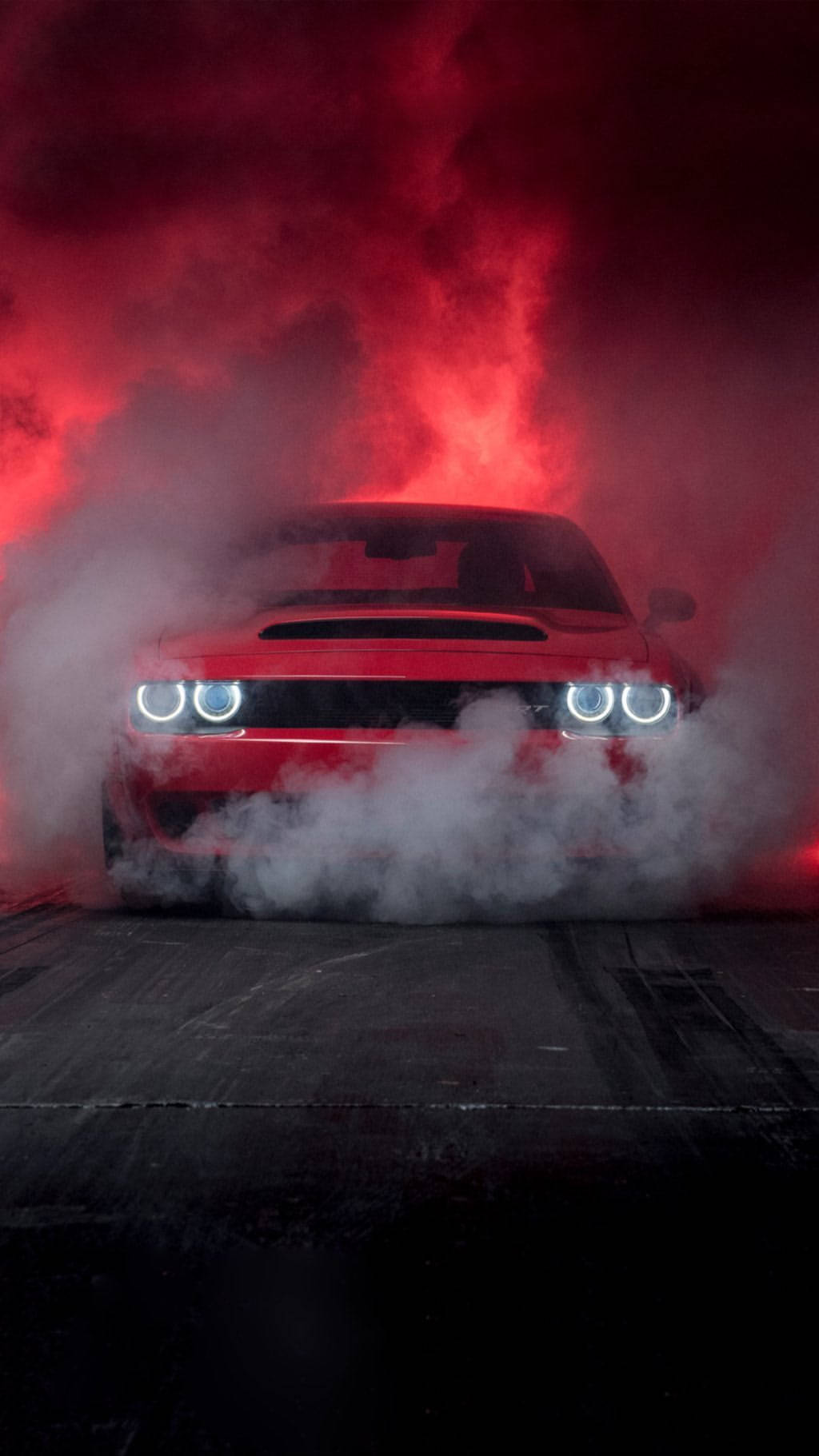 Sports Car 桌布 壁紙 — 一輛紅色肌肉車在漆黑的賽道上進行燒胎，周圍籠罩著濃煙和發光的紅色環境光。