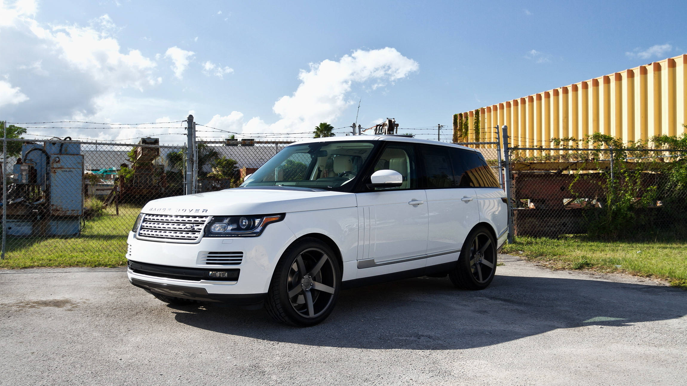 Range Rover Sport Jeep 壁紙 — 一輛純白色的Range Rover SUV停在瀝青路面上，天空湛藍，白雲點綴。