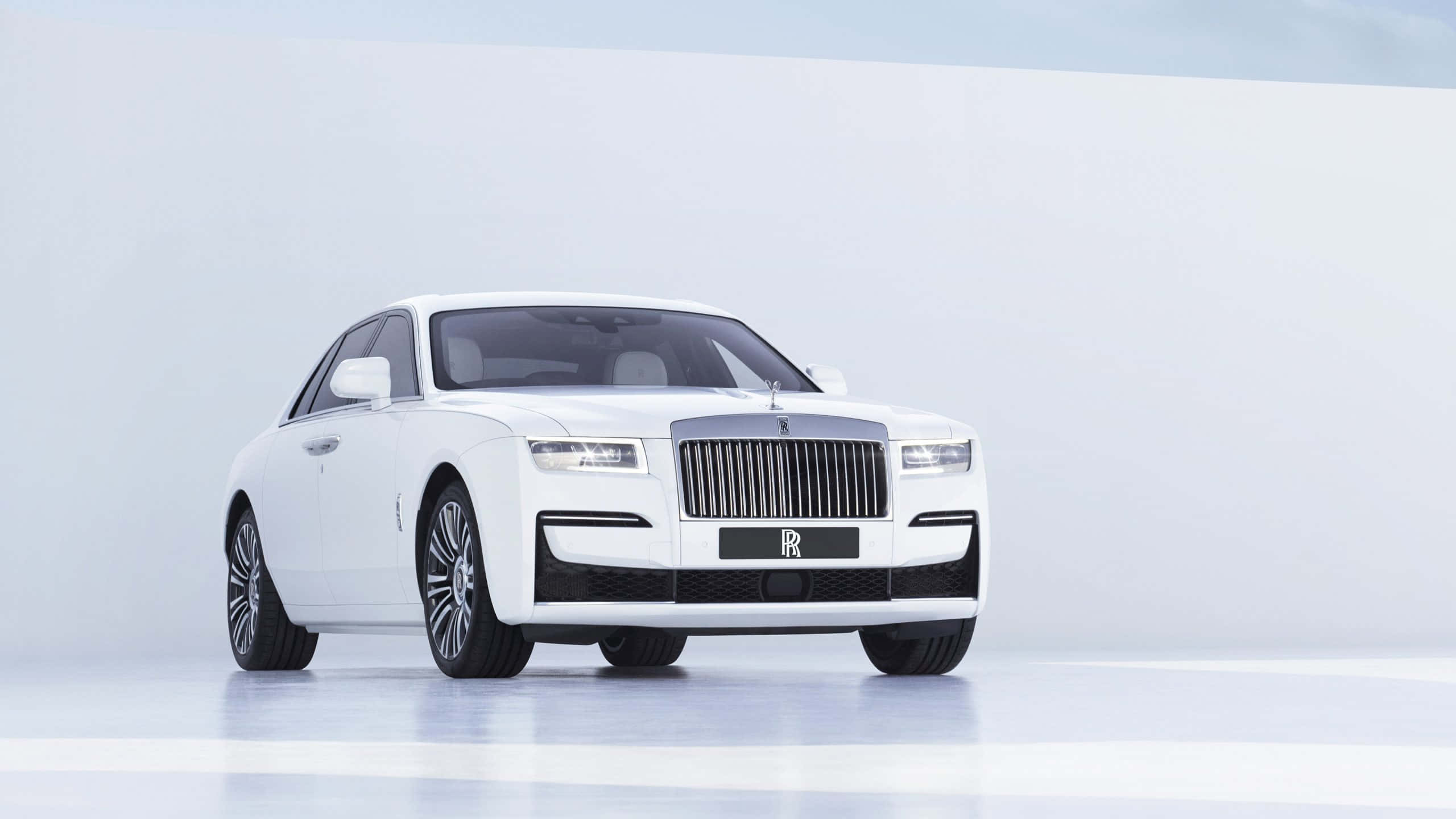 Rolls Royce 桌布 壁紙 — 一輛純白色的勞斯萊斯 Ghost 在柔和的工作室燈光下，在極簡的白色背景前閃閃發光。