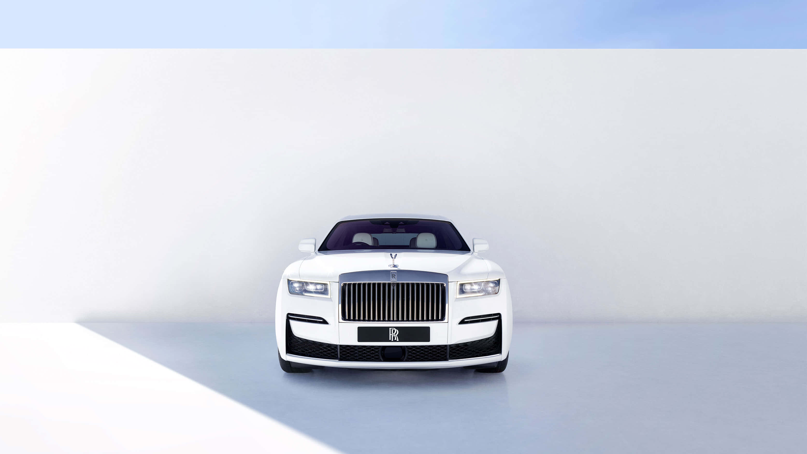 Rolls Royce 桌布 壁紙 — 一輛純白色的勞斯萊斯在柔和日光下，以極簡白色工作室背景為襯，置中停放。