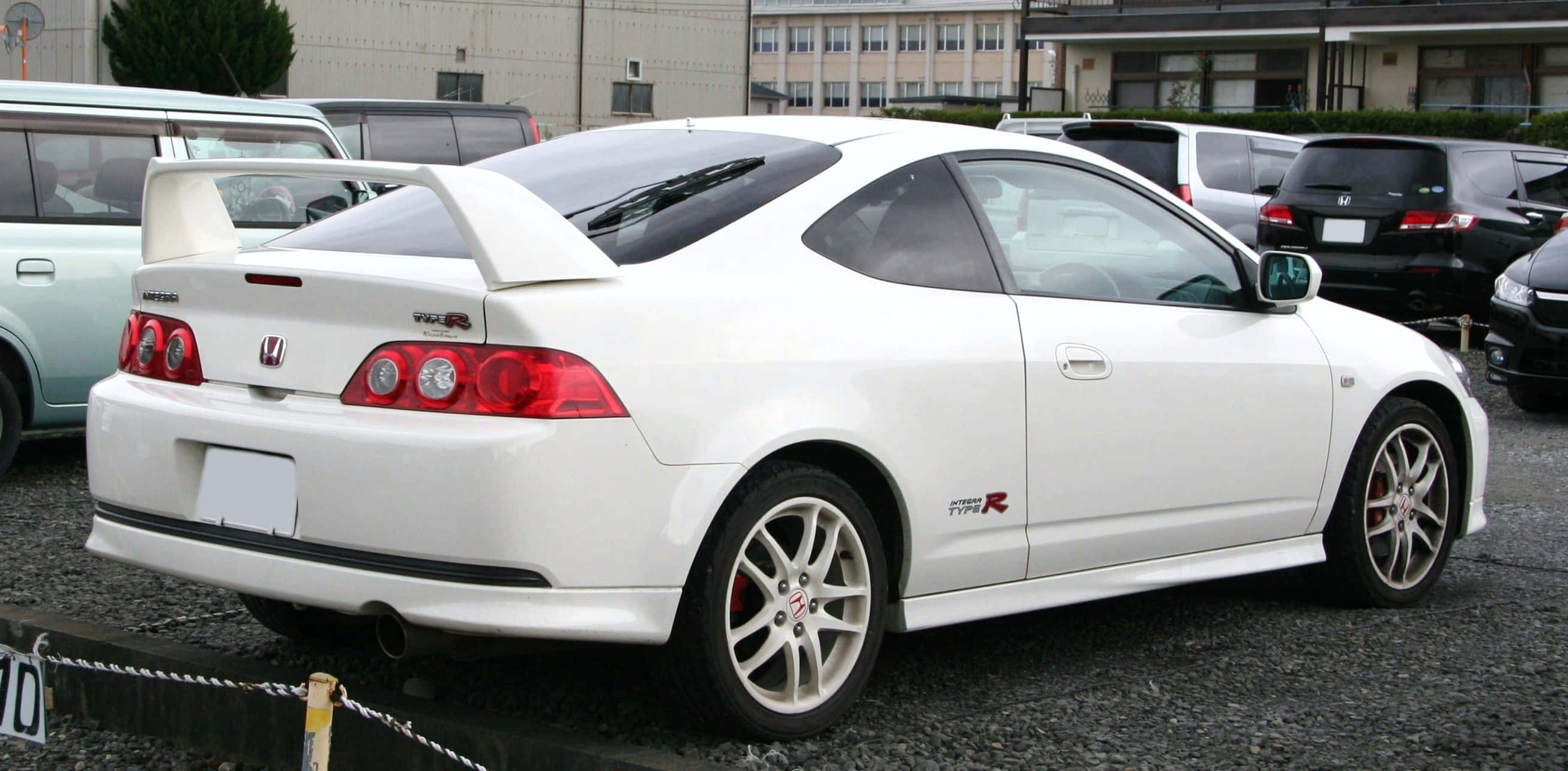 Honda Integra 桌布 壁紙 — 一輛純白色的本田思域Type R雙門跑車停泊在碎石停車場，附近有其他車輛。