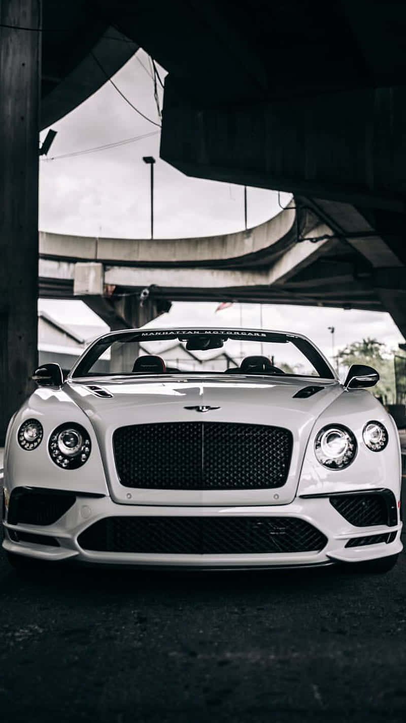 Bentley Continental Gt 桌布 壁紙 — 一輛純白色的賓利 Continental GT Speed 敞篷車停在混凝土天橋下，上方有戲劇性的燈光。