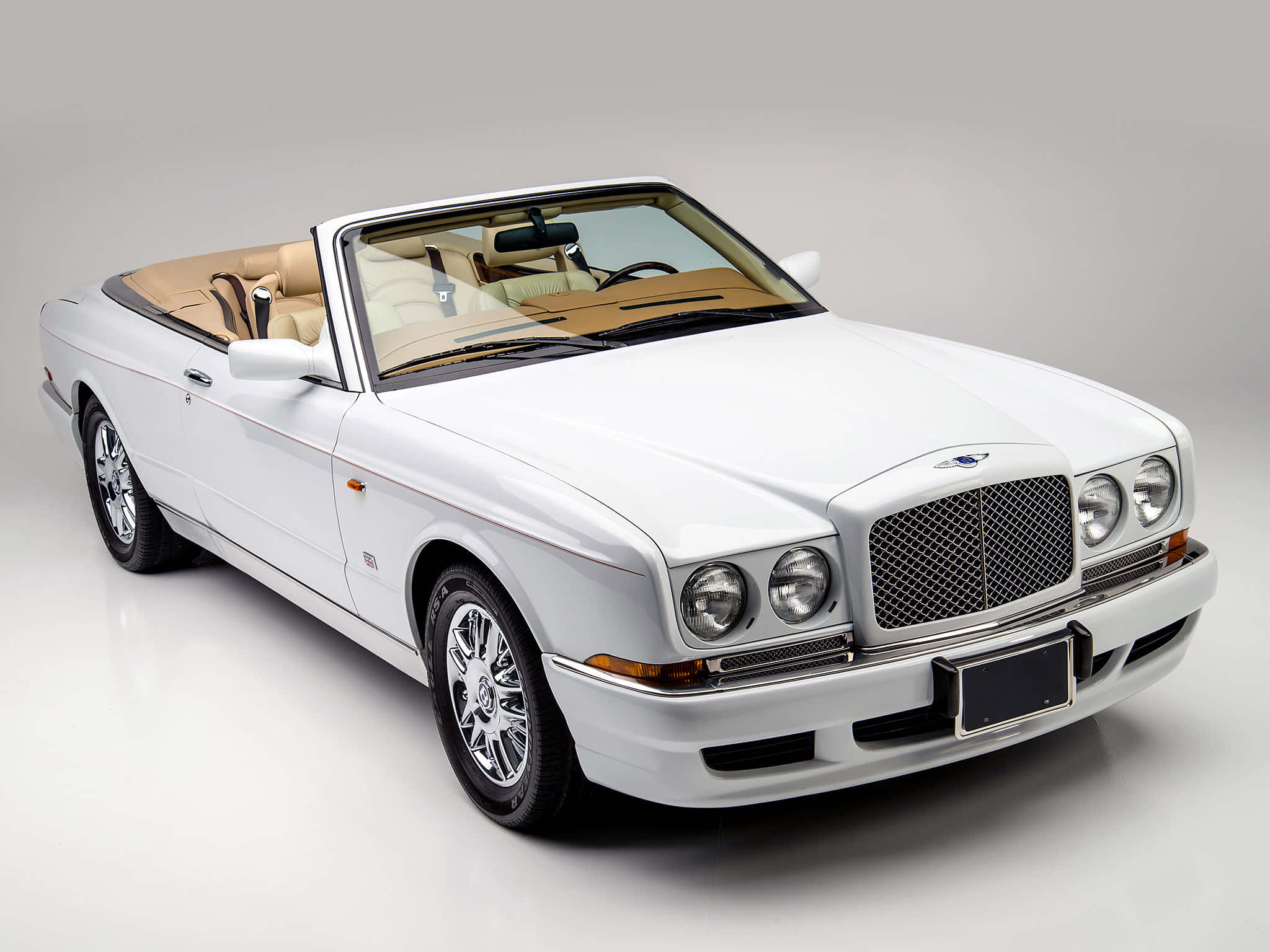 Bentley Azure 桌布 壁紙 — 一輛純白色賓利開篷車，配備淺褐色皮革內飾，在極簡主義的攝影棚環境中展示。