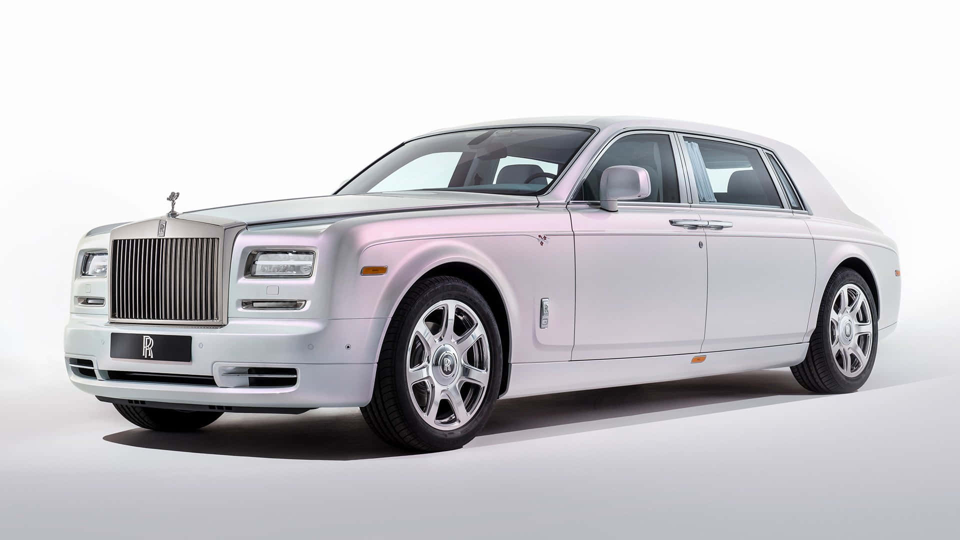 Rolls Royce 桌布 壁紙 — 一輛純銀色的勞斯萊斯幻影在攝影棚燈光下，在無縫白色背景上閃閃發光。