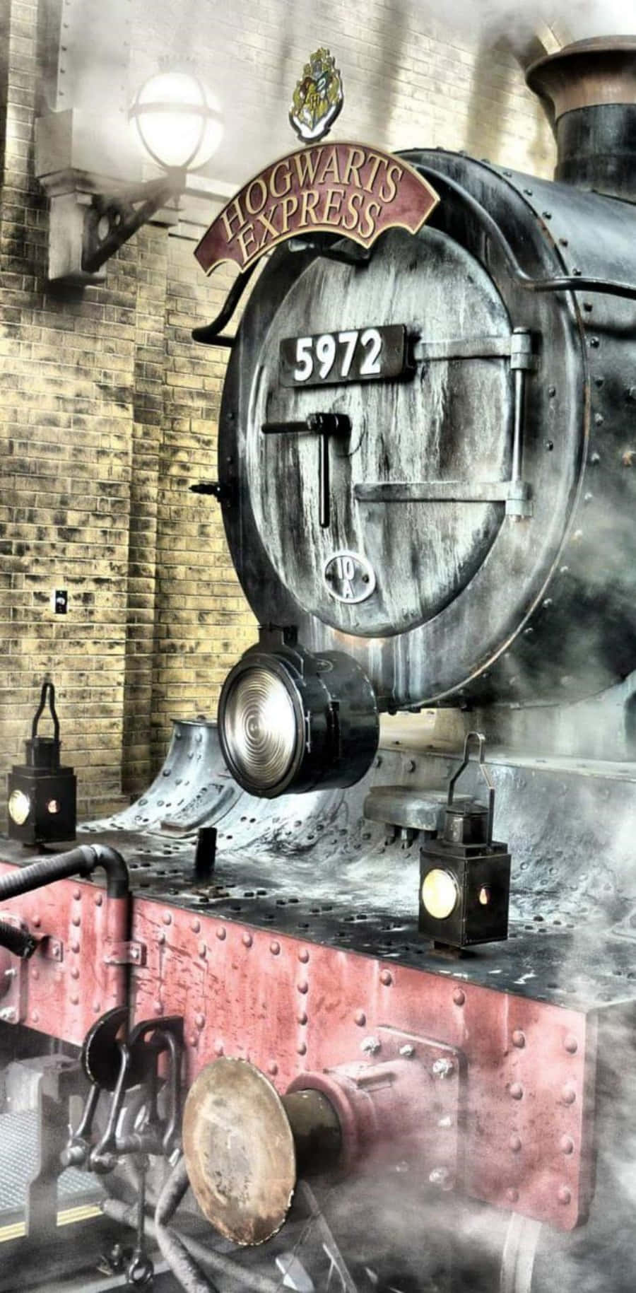 The Hogwarts Express Train 桌布 壁紙 — 一輛編號5972的雄偉霍格華茲特快蒸汽火車頭，冒著濃煙駛過磚造車站。