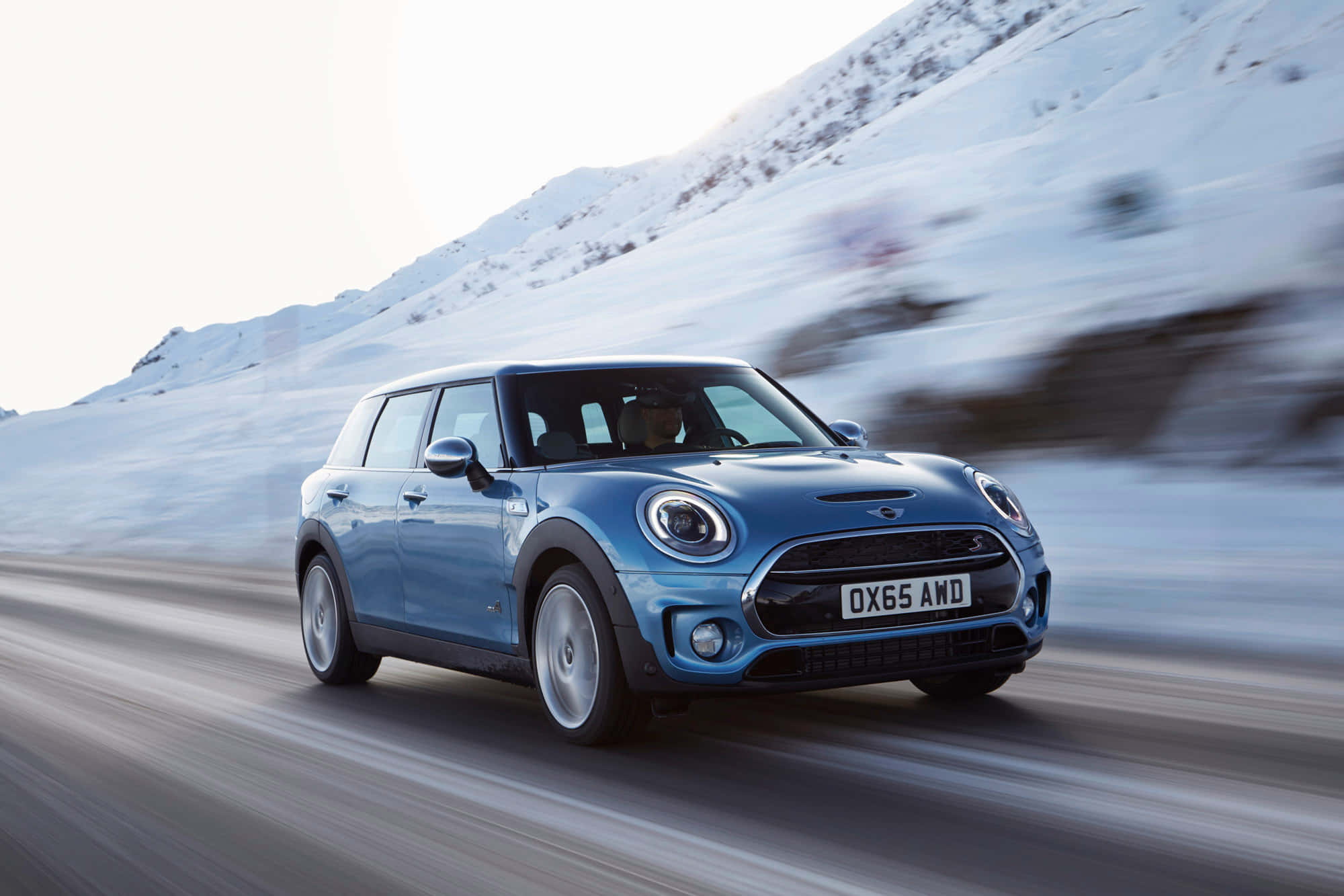 Mini Cooper S Clubman All4 桌布 壁紙 — 一輛藍色MINI Countryman在積雪的山路上疾馳，動態模糊傳達出動感。