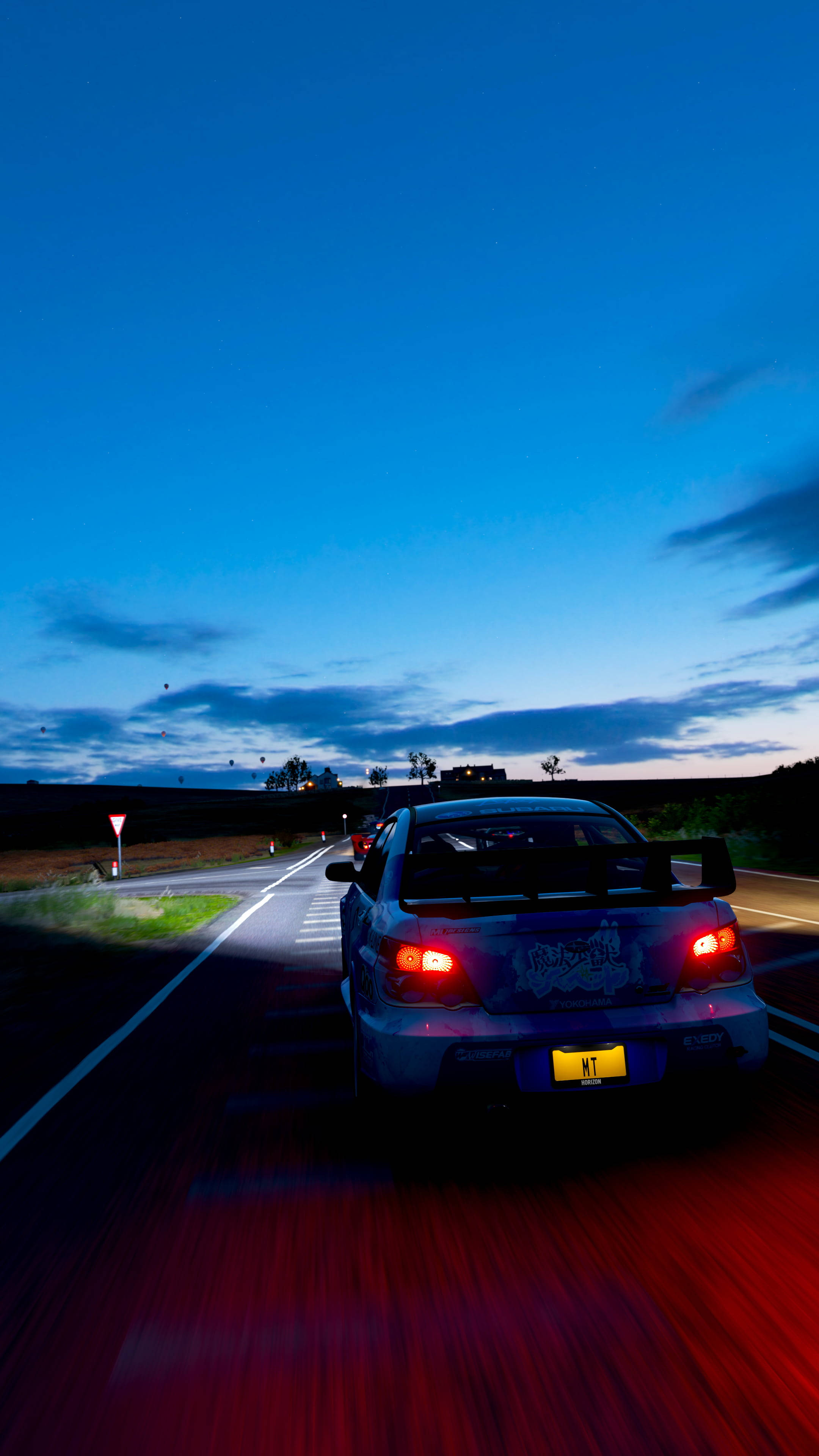subaru 桌布 壁紙 — 一輛藍色拉力賽車在黃昏時分的鄉村道路上疾馳，紅色尾燈在深藍色的天空中劃出線條。