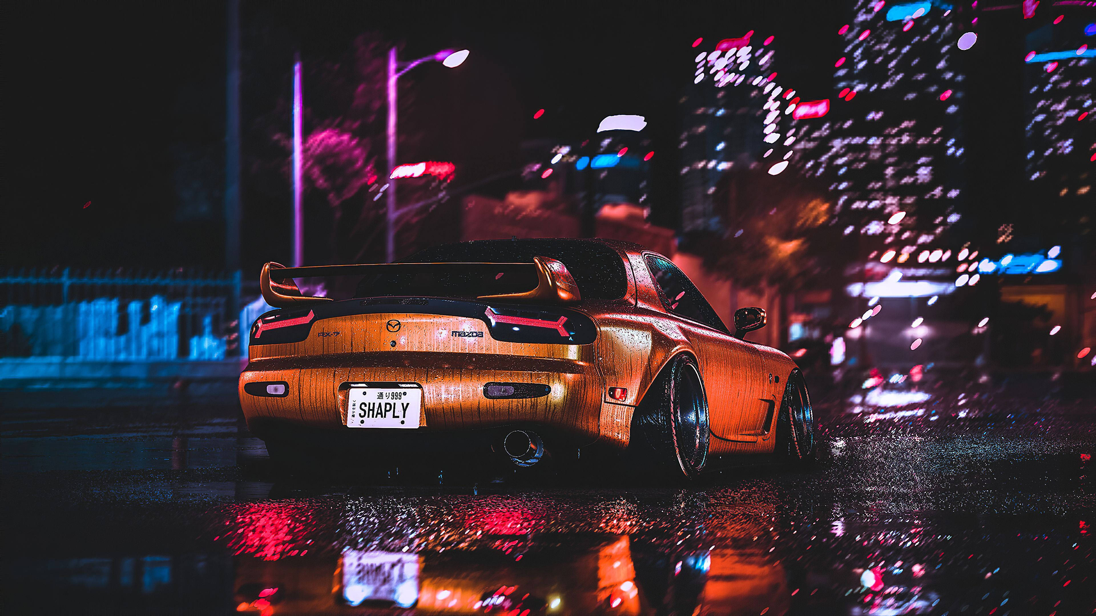 Jdm 美學 桌布 壁紙 — 一輛金色跑車在夜間濕漉漉的城市街道上閃閃發光，其倒影在霓虹燈和雨水中閃爍。