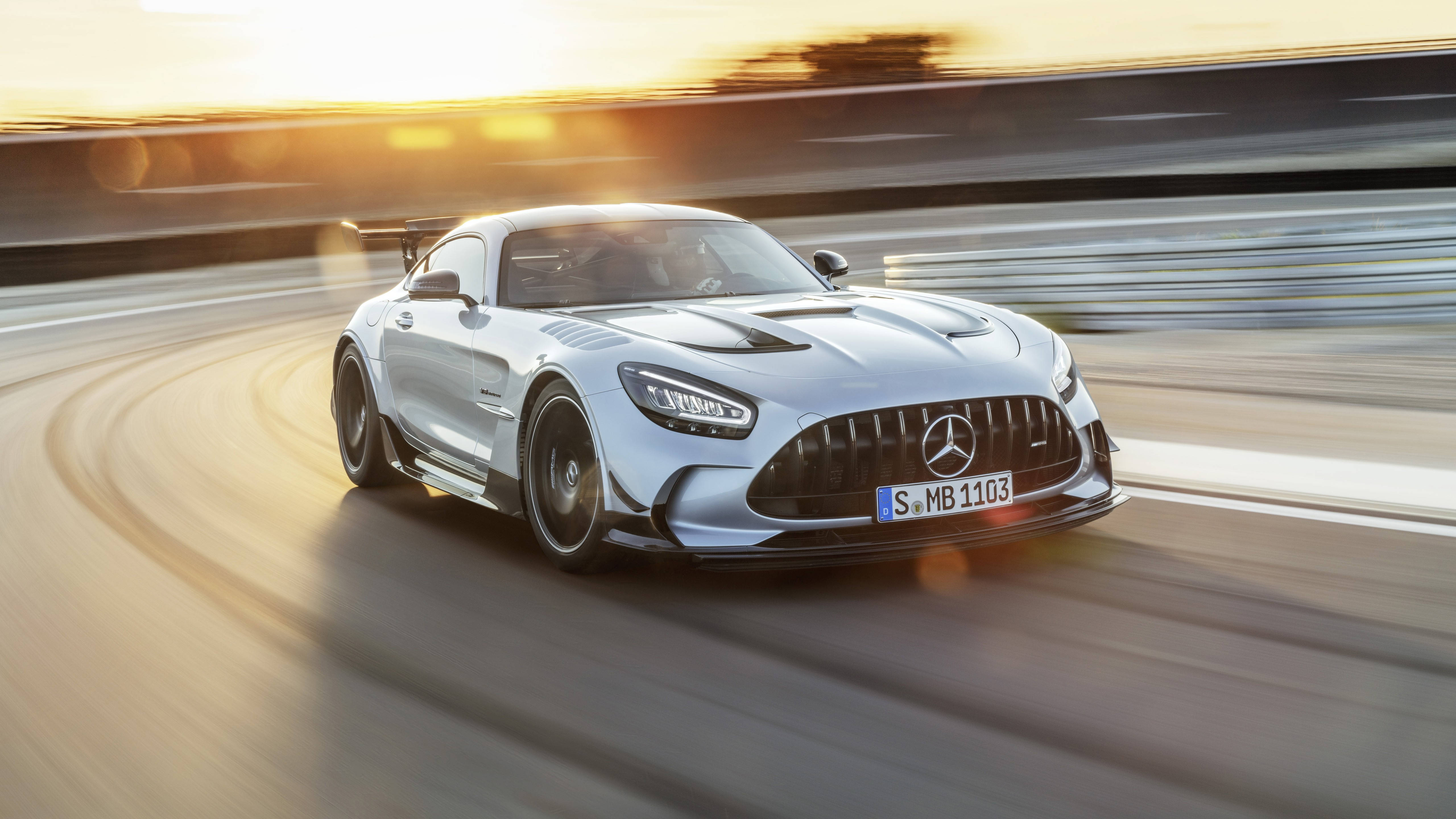 4K 桌布 壁紙 — 一輛銀色 Mercedes-AMG GT Black Series 在日落時分沿著蜿蜒的賽道奔馳，動態模糊效果強調了速度。