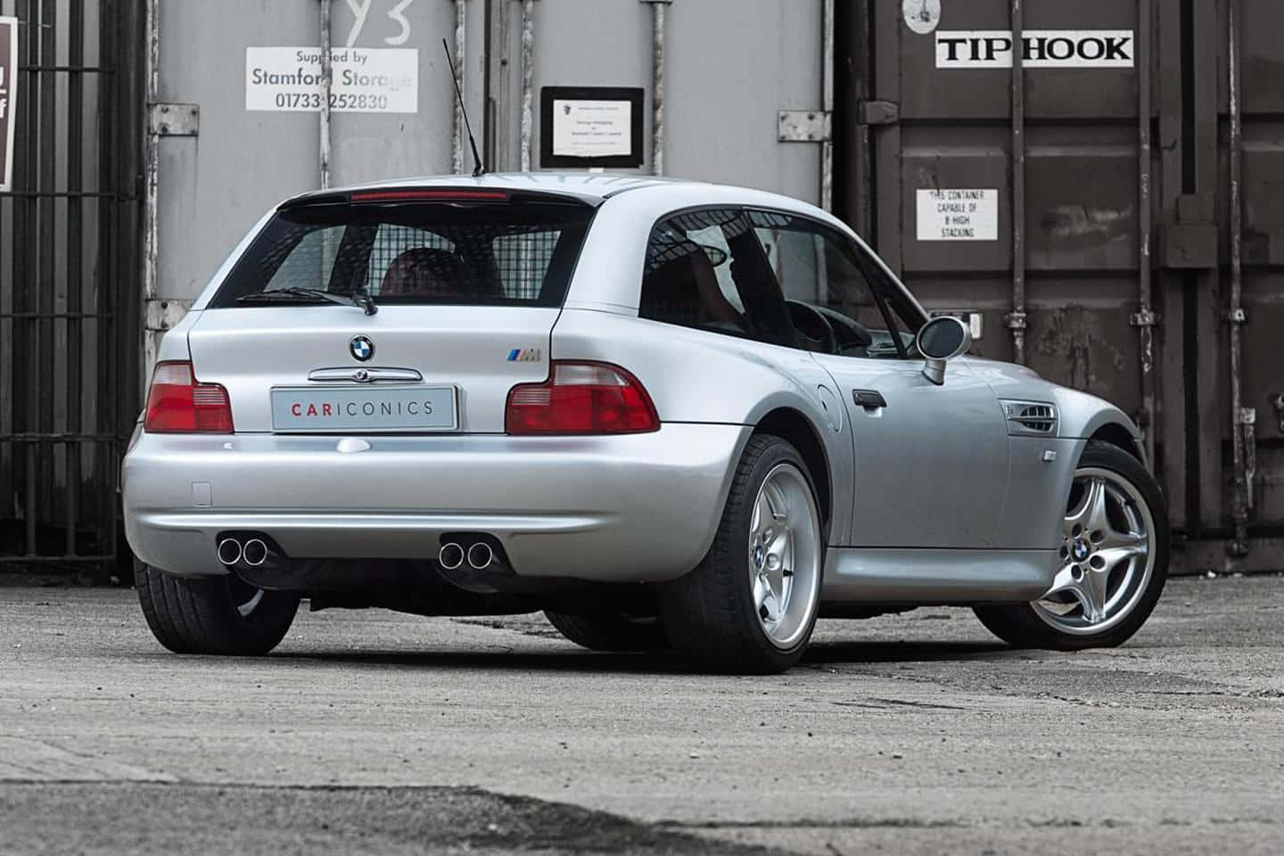 Bmw Z3 桌布 壁紙 — 一輛銀色BMW Z3 M Coupe停泊在工業儲存設施，可見排氣管和合金輪圈。