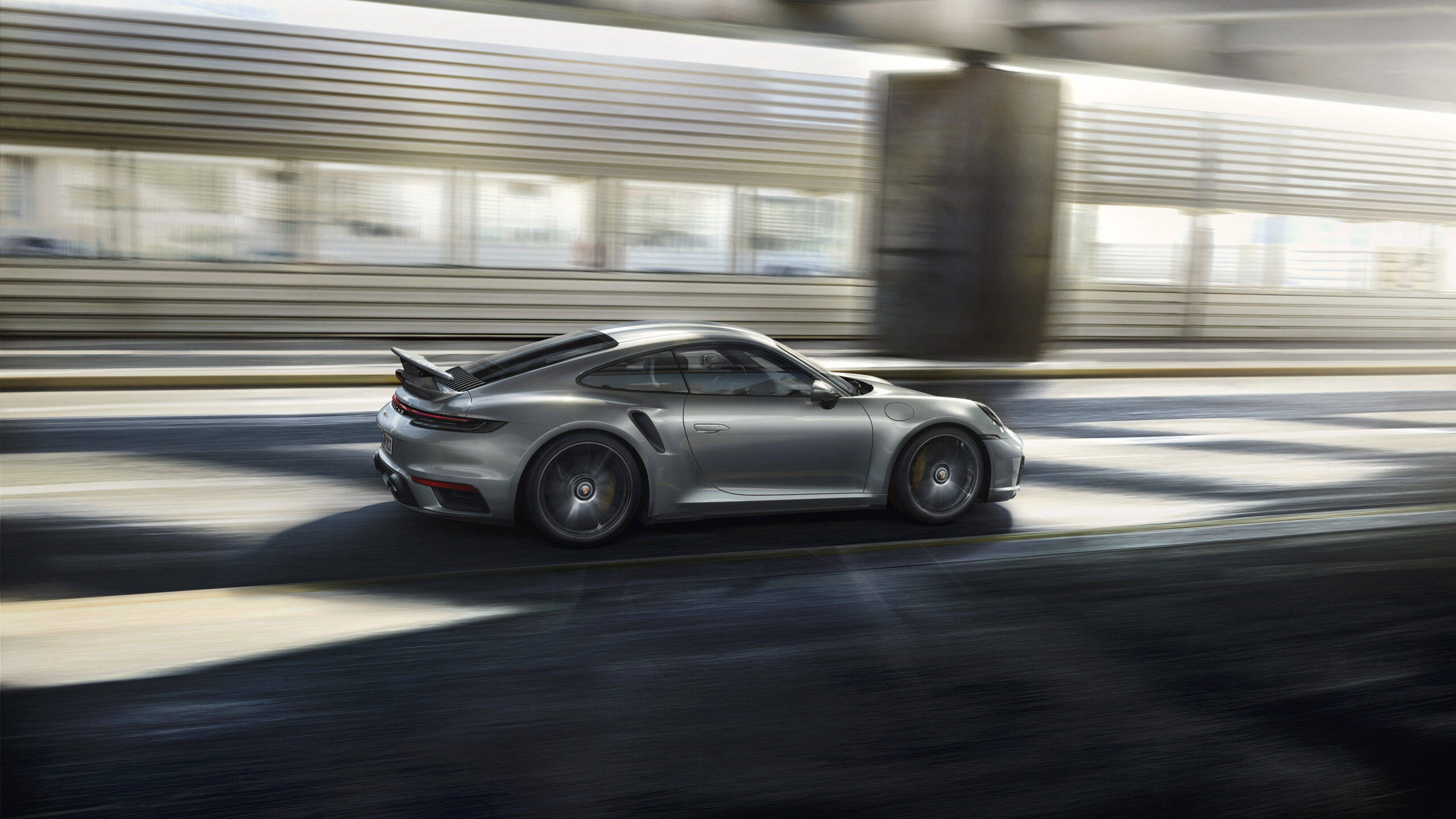 保時捷 桌布 壁紙 — 一輛銀色保時捷911 Turbo S在都市隧道中疾馳，背景呈現動態模糊效果。