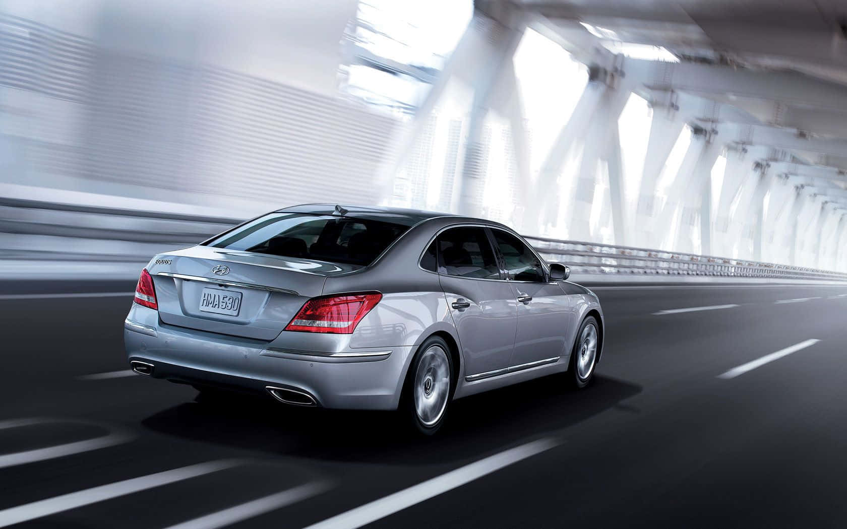 Hyundai Equus 桌布 壁紙 — 一輛銀色轎車在明亮現代隧道中疾馳，道路和牆壁呈現動態模糊效果。