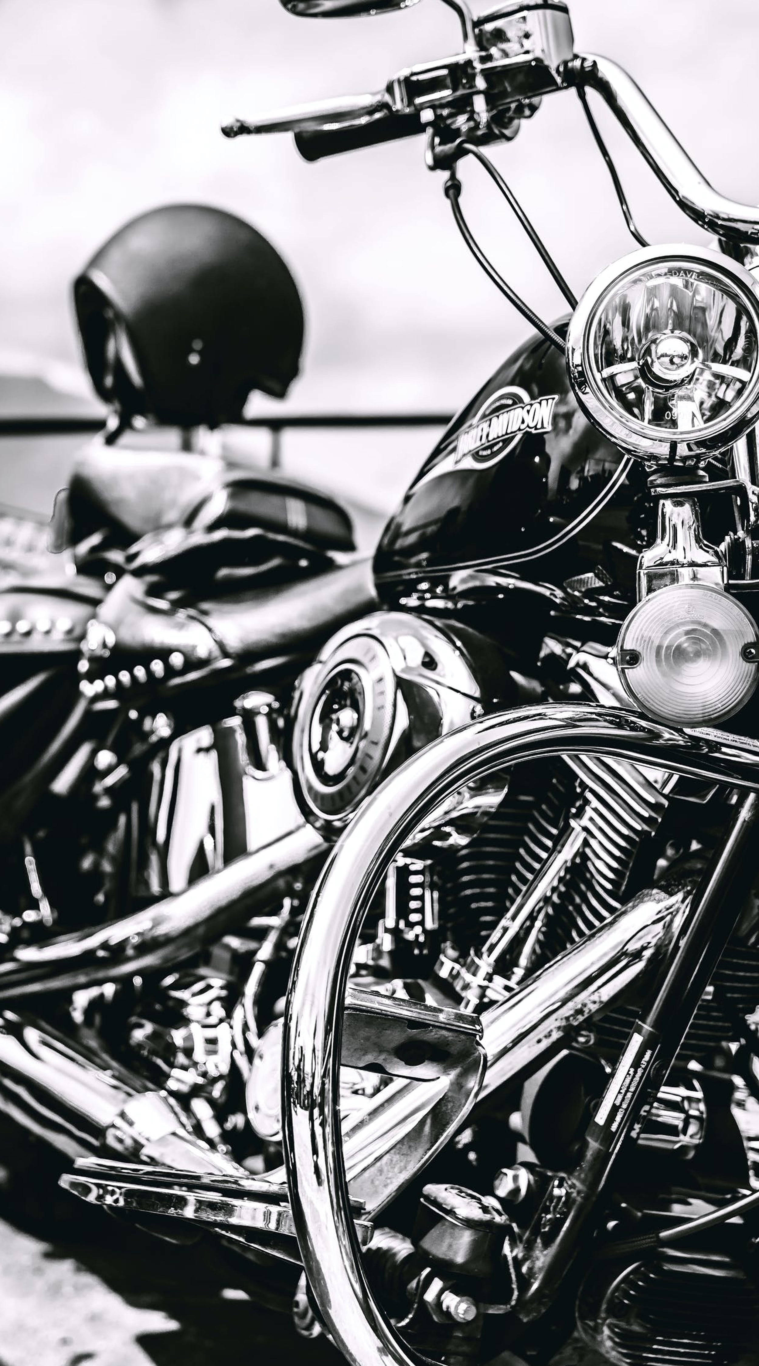 哈雷戴維森 桌布 壁紙 — 一輛閃亮的Harley-Davidson電單車黑白特寫，頭盔放在座椅上。