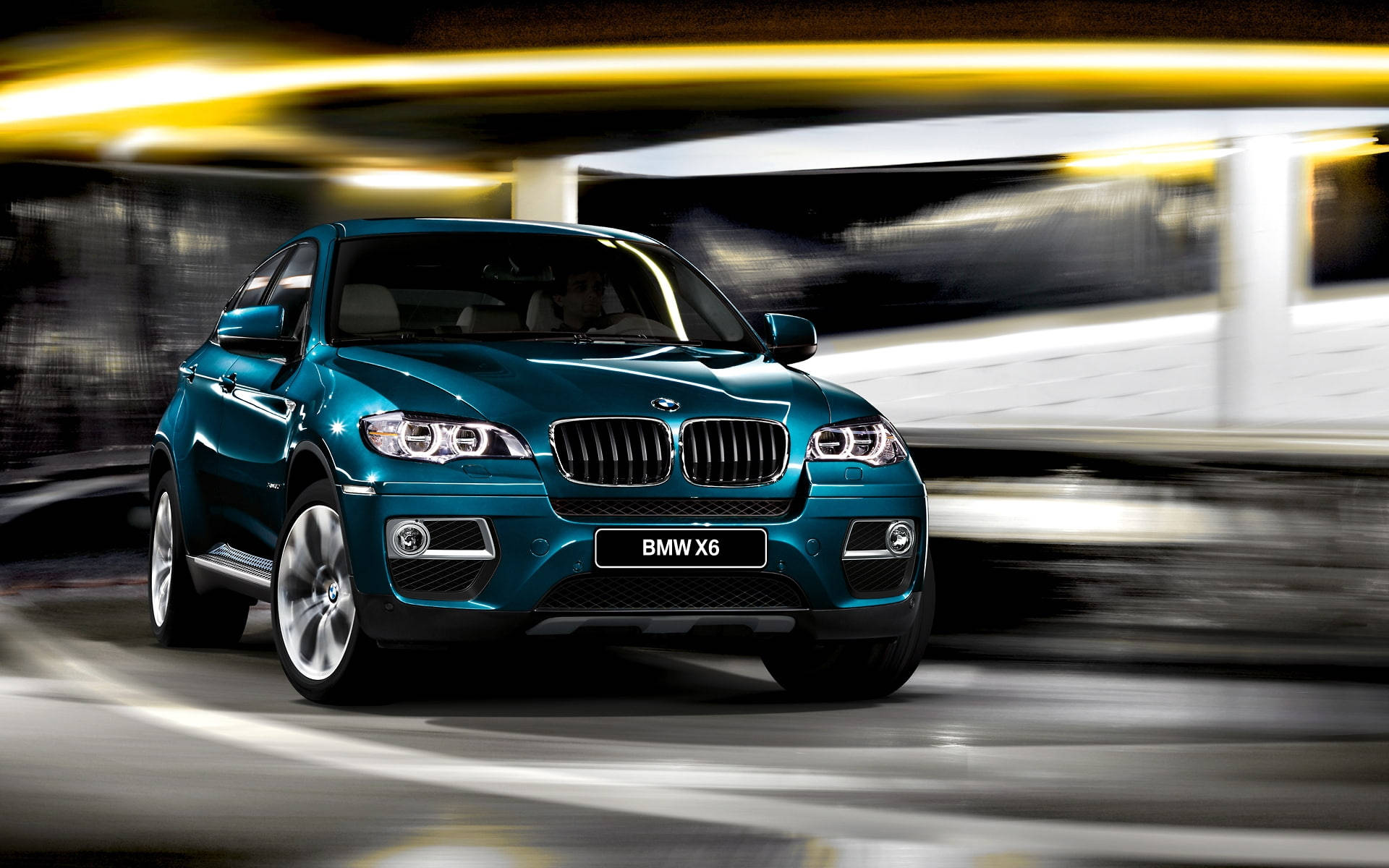 2013 BMW X6 M 壁紙 — 一輛青綠色的BMW X6在隧道中疾馳，帶有動態模糊和閃爍的黃色燈光掠過。