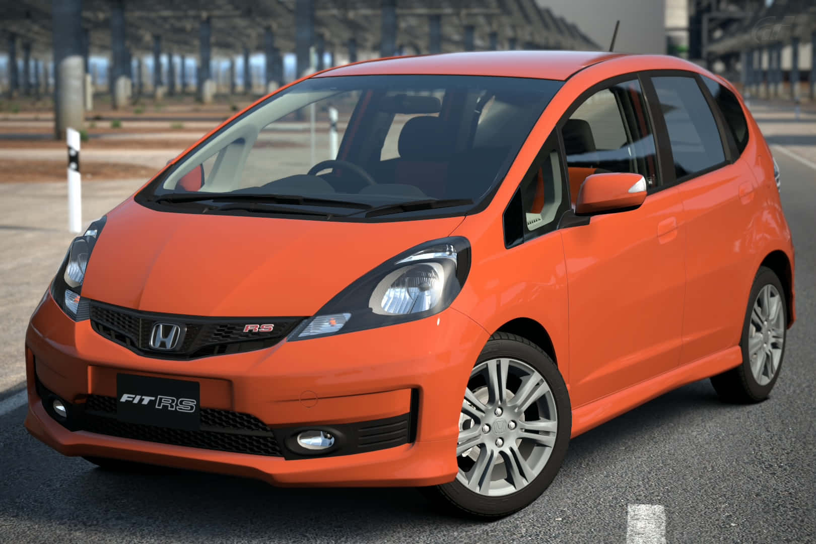 Honda Fit 桌布 壁紙 — 一輛鮮橙色的本田 Fit RS 在明亮的日光下停泊在瀝青路上，背景有工業建築。
