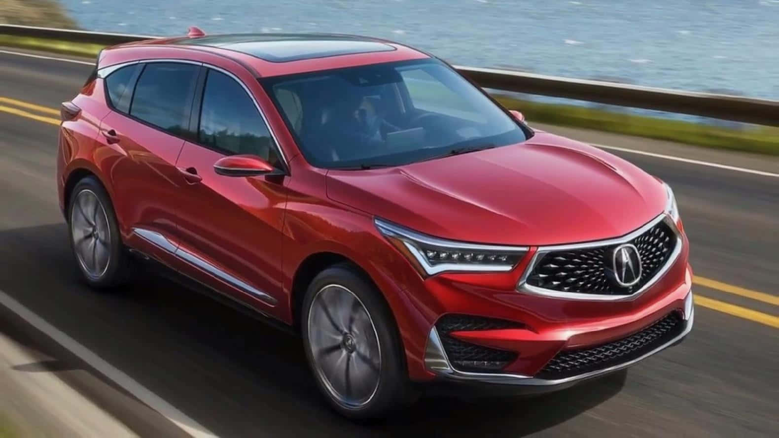 Acura Mdx 桌布 壁紙 — 一輛鮮紅色的Acura SUV沿著海岸公路行駛，背景中海浪拍打。