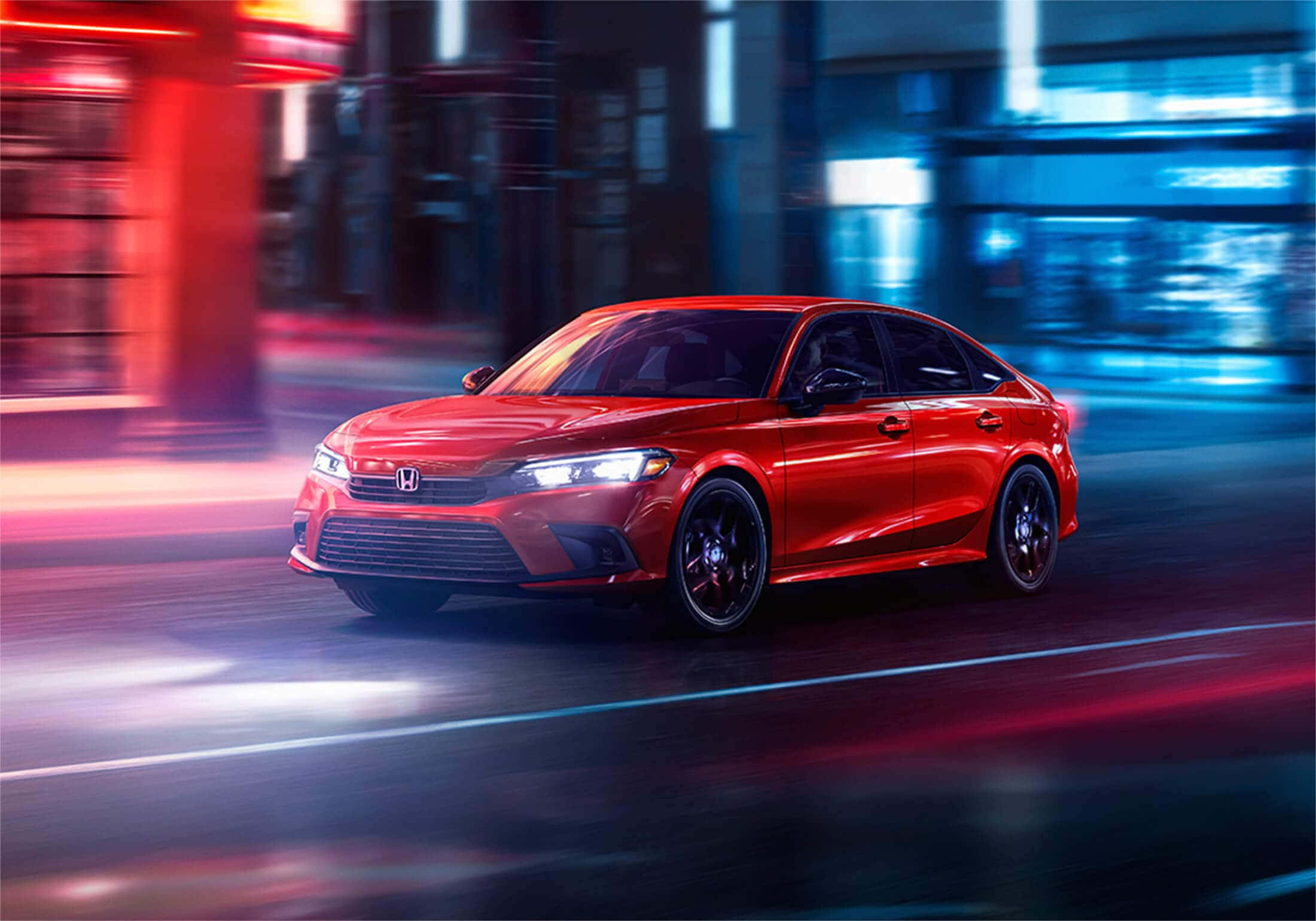 Honda Civic 桌布 壁紙 — 一輛鮮紅色的本田房車在夜晚穿過霓虹燈閃爍的城市街道，帶有紅色和藍色燈光的動態模糊痕跡。