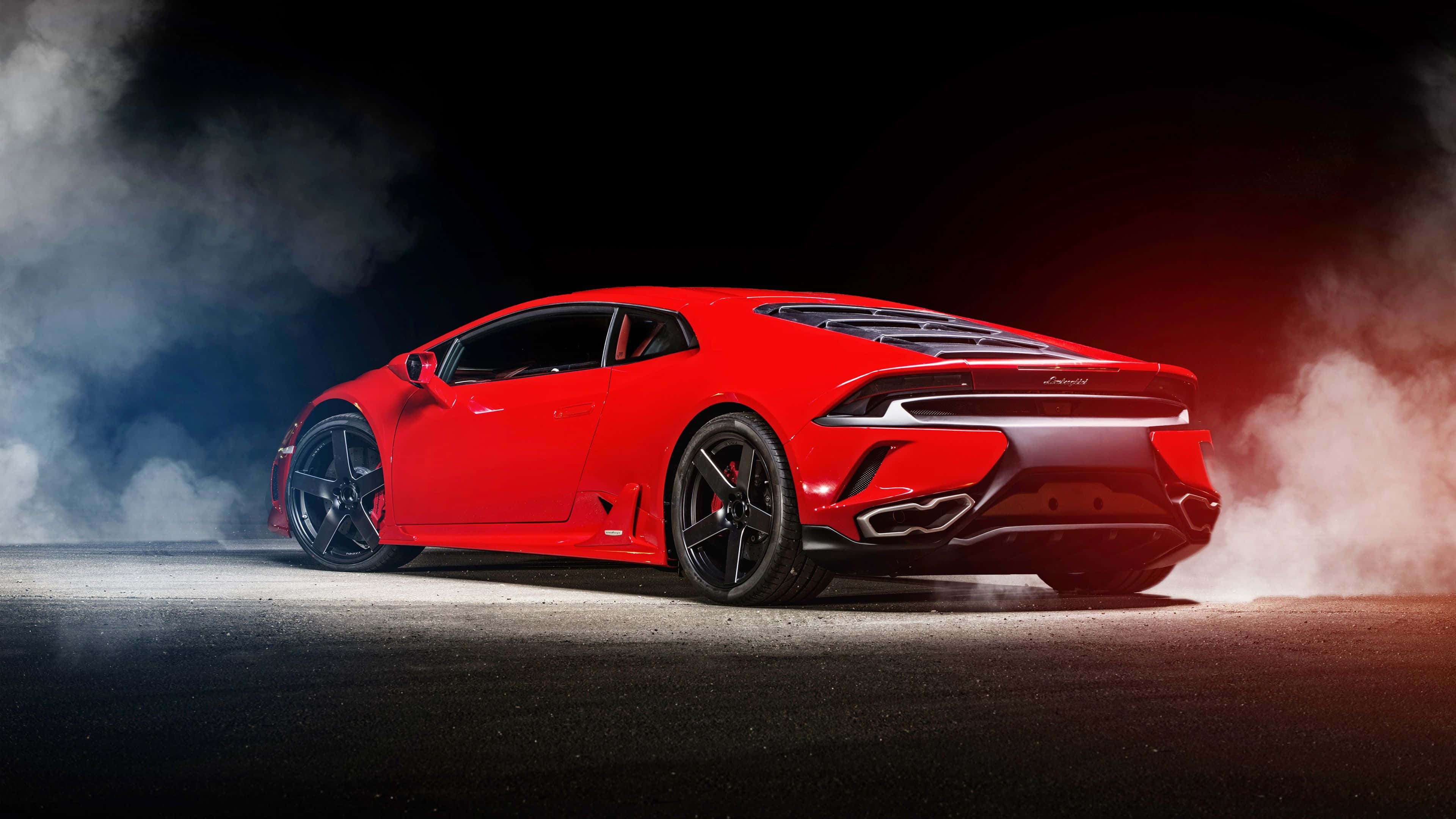 Car Design 桌布 壁紙 — 一輛鮮紅色的林寶堅尼Huracán在戲劇性燈光下，於黑暗的瀝青賽道上冒煙飄移。