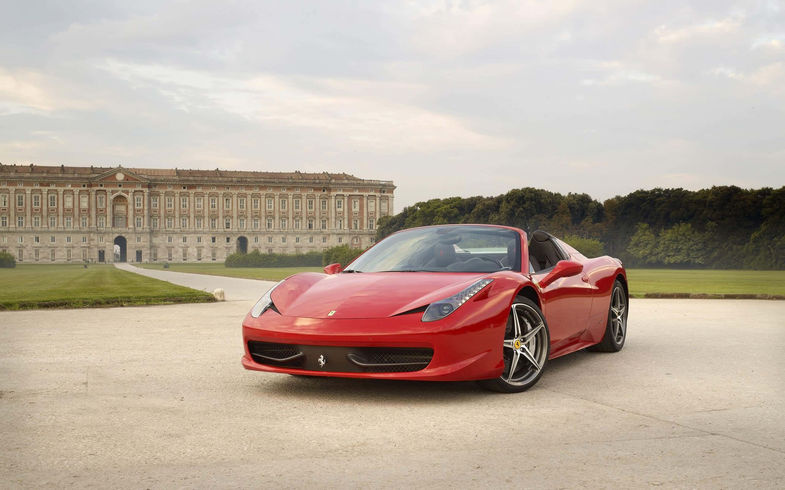 Ferrari 488 Spider 桌布 壁紙 — 一輛鮮紅色的法拉利458 Spider停泊在碎石車道上，前方是一座宏偉的歷史宮殿，擁有修剪整齊的草坪和多雲的天空。