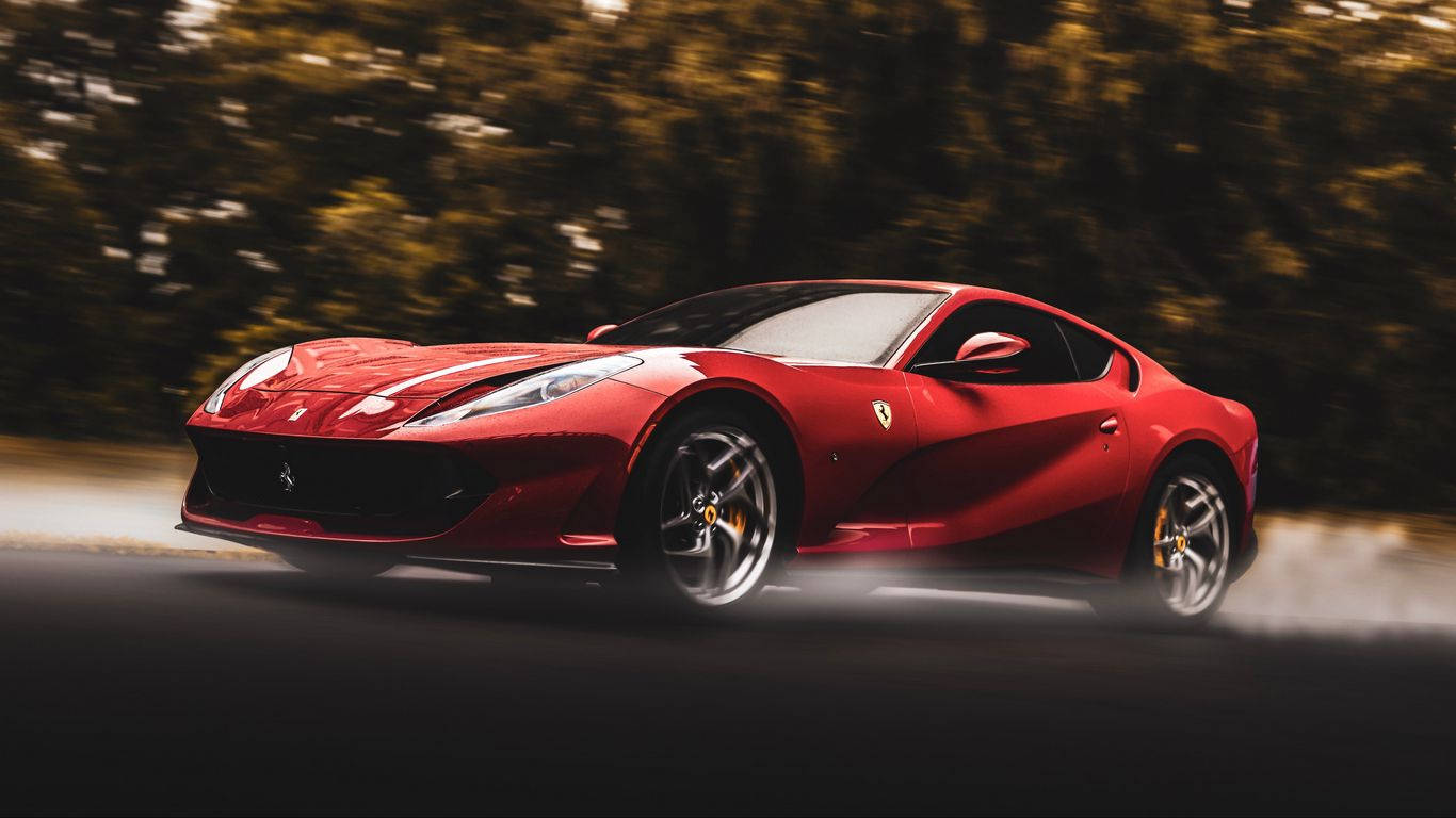 Sports Car 桌布 壁紙 — 一輛鮮紅色的法拉利跑車在黑暗的道路上疾馳，背景是模糊的金色樹葉。