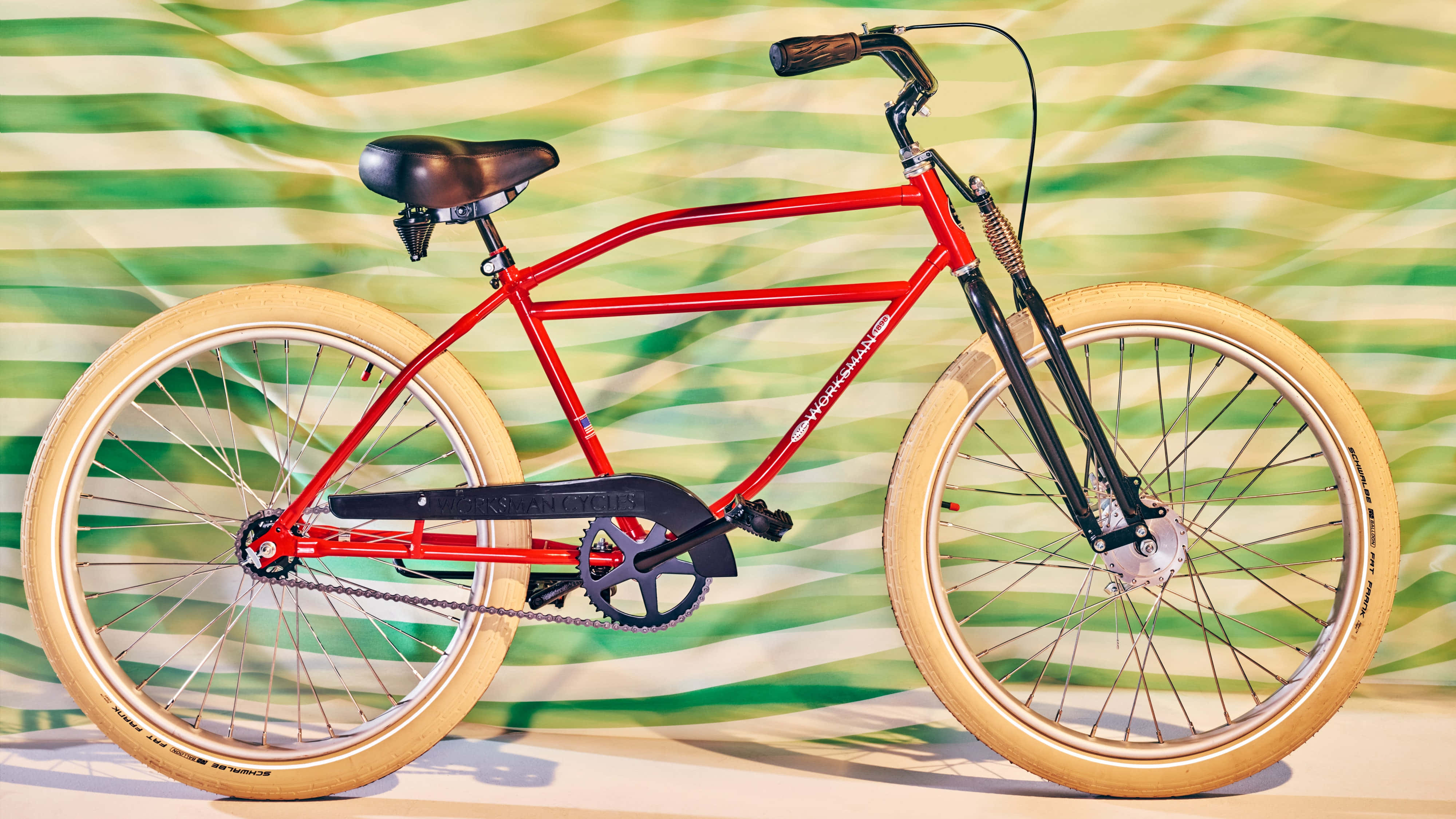 Beach Cruiser 桌布 壁紙 — 一輛鮮紅色的自行車配奶油色輪胎，立在波浪形綠白條紋背景前。