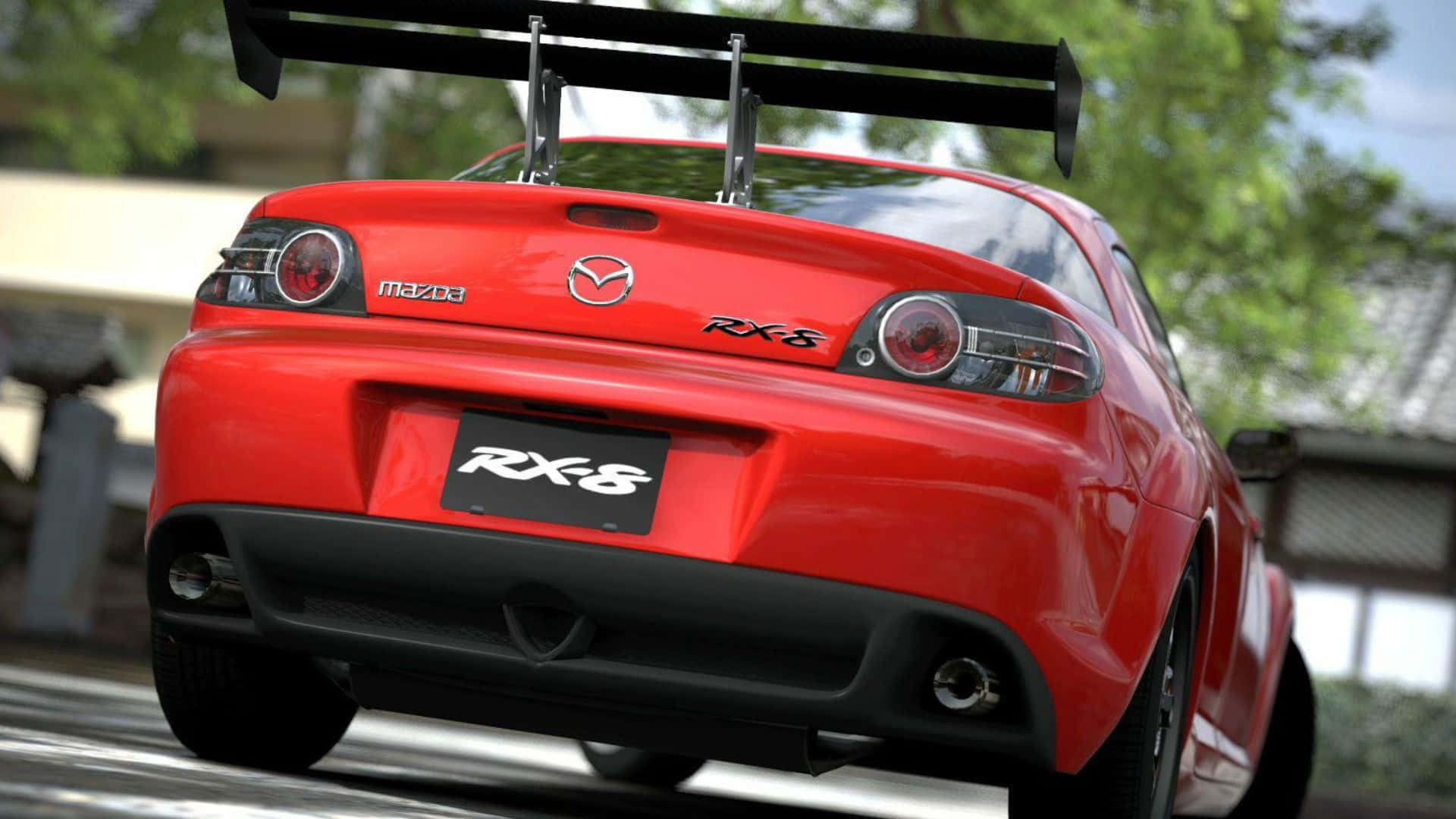 Mazda Rx-8 桌布 壁紙 — 一輛鮮紅色的萬事得RX-8跑車，帶有大型後擾流板，從後方拍攝，背景是綠樹成蔭的道路。