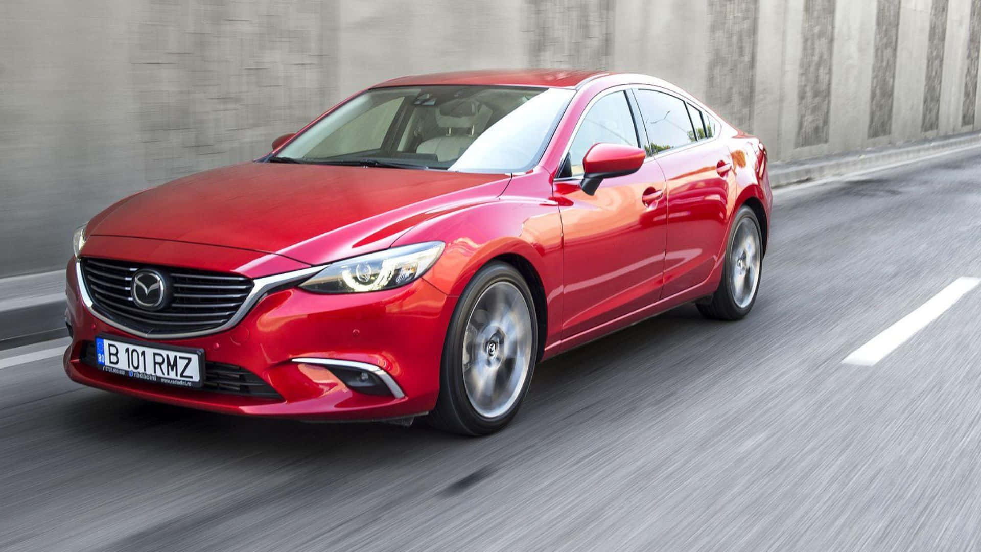 Mazda 6 桌布 壁紙 — 一輛鮮紅色的萬事得房車在混凝土路上疾馳，動態模糊效果強調其動感移動。