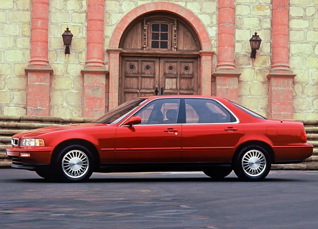Acura Legend 桌布 壁紙 — 一輛鮮紅色轎車停在一座帶有拱形木門和燈籠的石建築前。