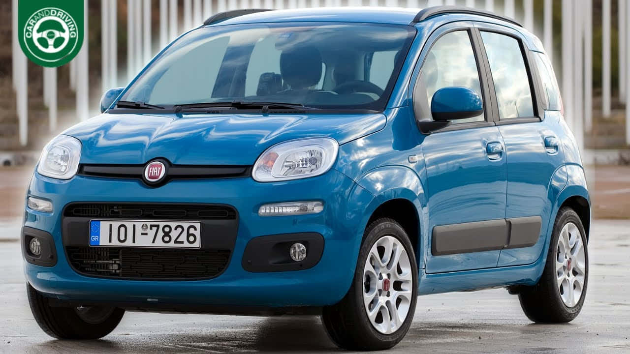Fiat Panda 桌布 壁紙 — 一輛鮮藍色嘅Fiat Panda小型車泊喺濕嘅路面上，背景係模糊嘅垂直白色板條。