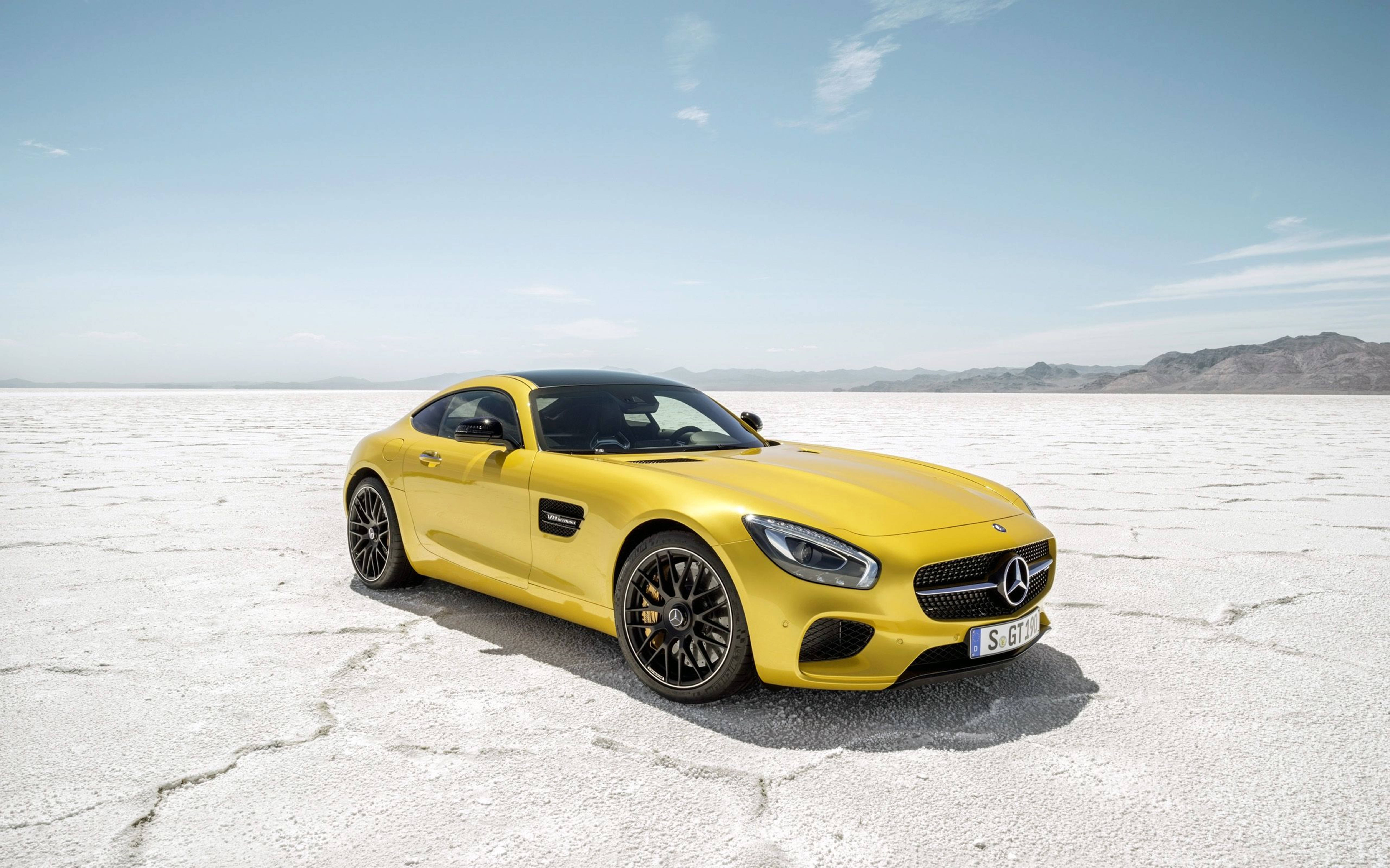 Mercedes 桌布 壁紙 — 一輛鮮黃色的 Mercedes-AMG GT S 跑車停泊在龜裂的白色鹽灘上，背景是清澈的藍天。