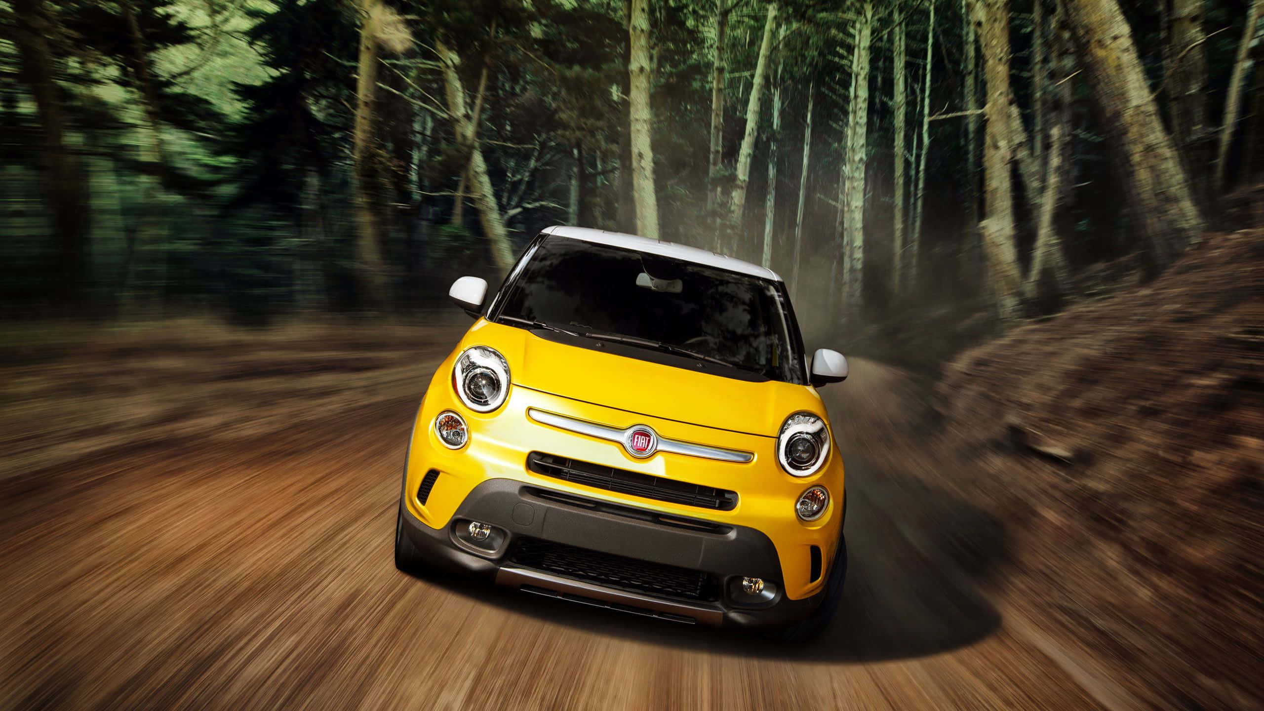 Fiat 500l 桌布 壁紙 — 一輛鮮黃色的Fiat 500L在森林泥路上疾馳，周圍帶有動態模糊效果。