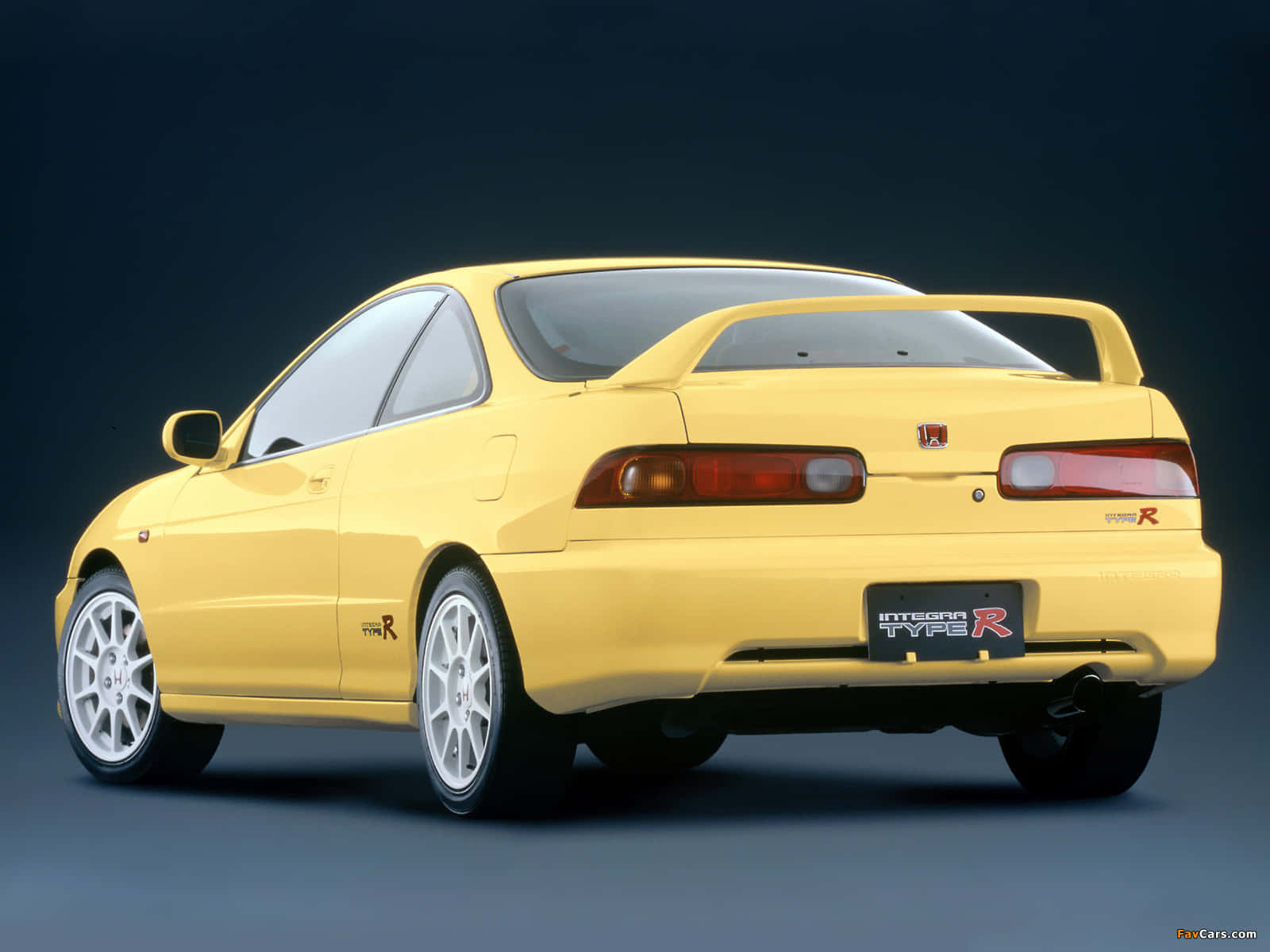 Honda Integra 桌布 壁紙 — 一輛鮮黃色的本田Integra Type R跑車，從後方四分之三角度拍攝，背景為深色攝影棚。