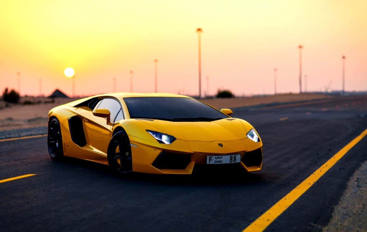 Yellow Car 桌布 壁紙 — 一輛鮮黃色的林寶堅尼Aventador在日落時分沿沙漠高速公路飛馳，溫暖的金色光芒沐浴著整個場景。