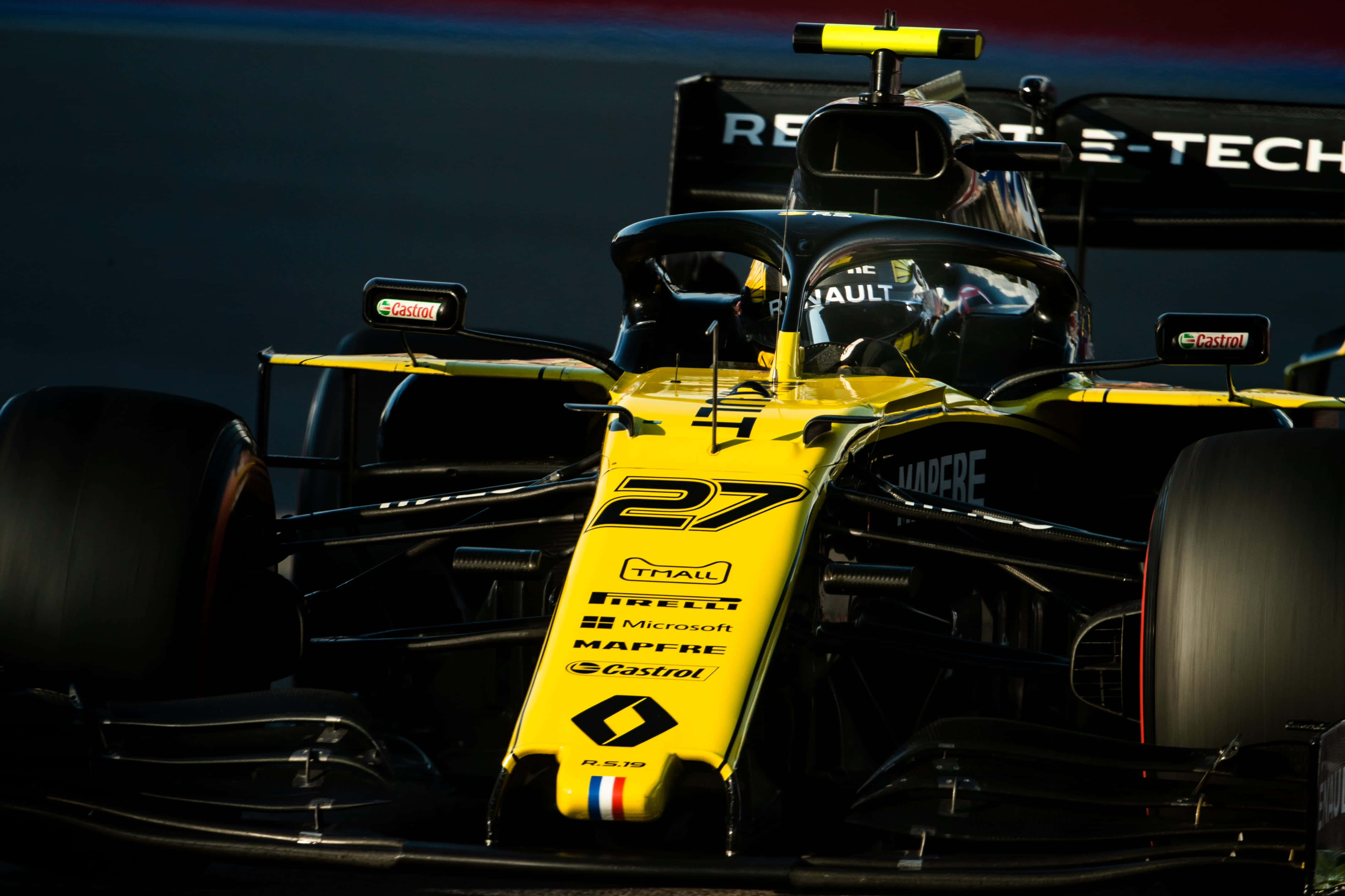 F1 2019 桌布 壁紙 — 一輛黃黑相間、編號27的一級方程式賽車在明亮燈光下於賽道上疾馳的特寫。