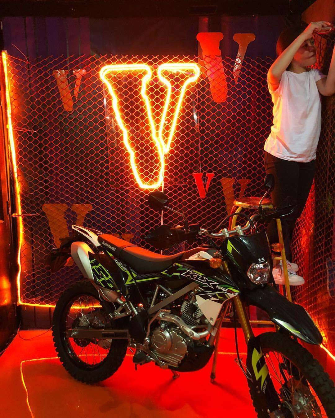 Vlone 桌布 壁紙 — 一輛黑綠色越野車在紅色霓虹燈下發光，一個人喺鐵絲網後面擺姿勢。