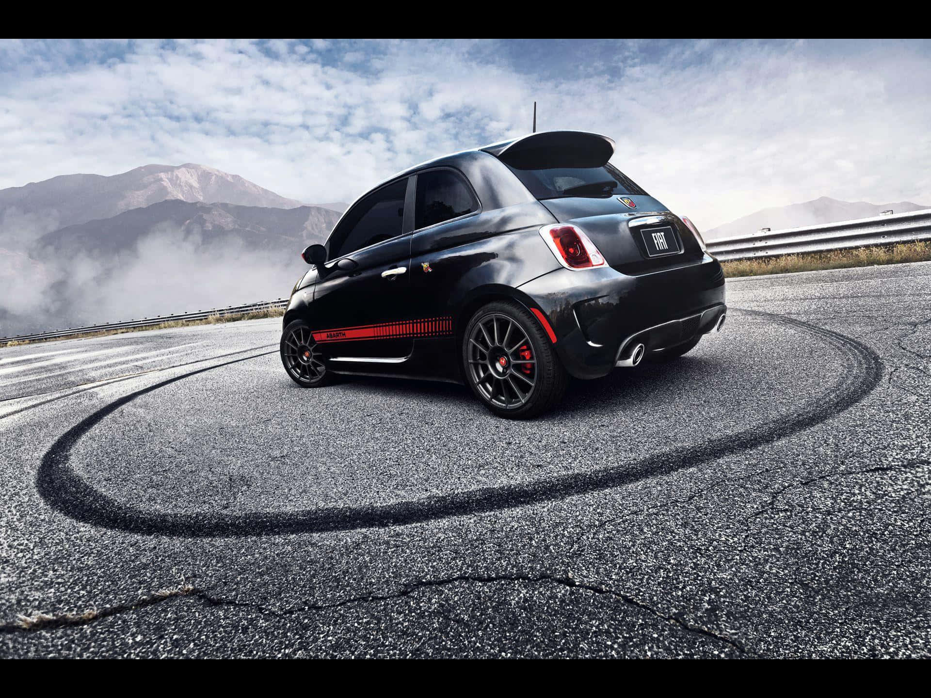Abarth 桌布 壁紙 — 一輛黑色Fiat 500 Abarth在山路上完美繞圈漂移，背景是霧氣繚繞的山峰。