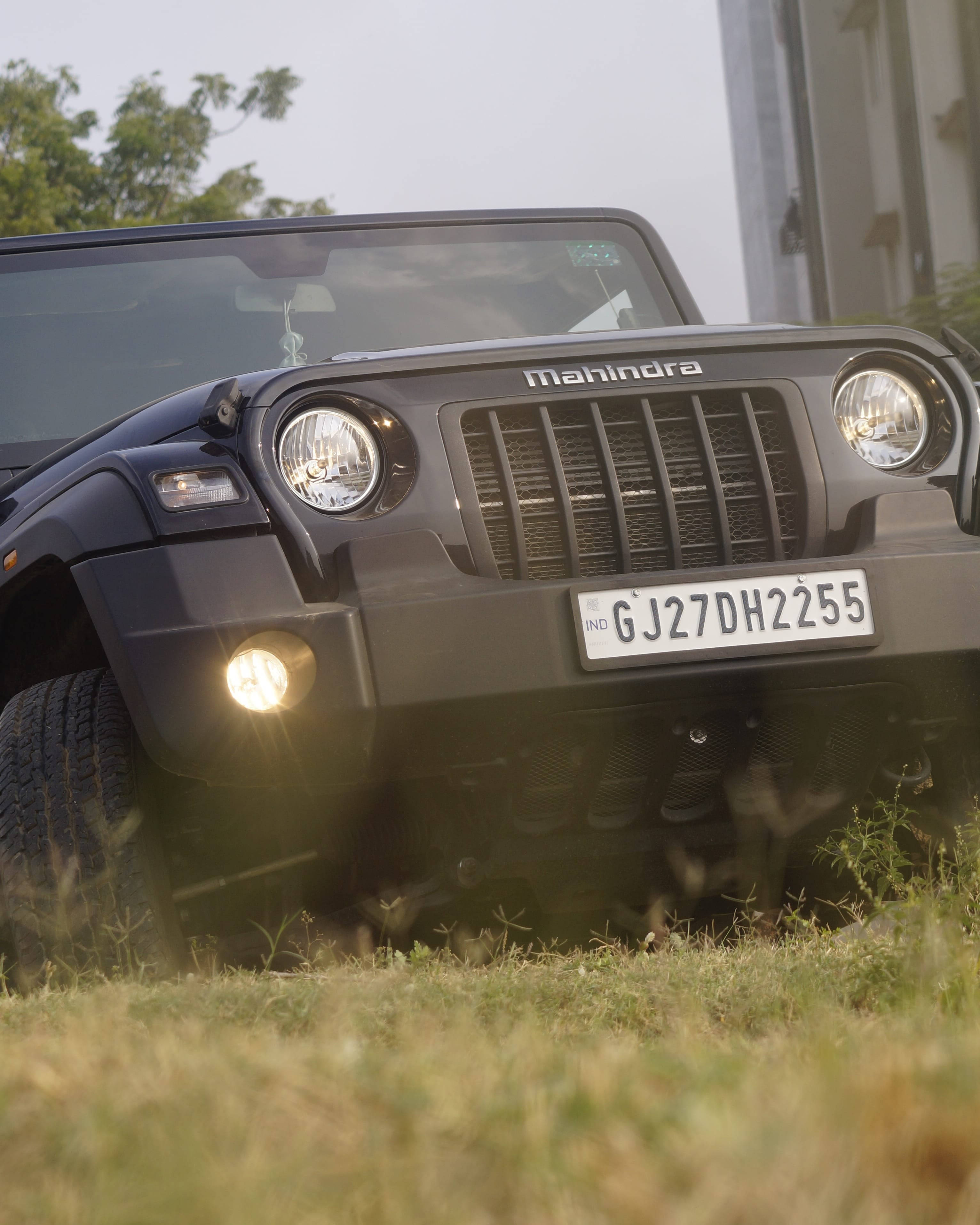 草 桌布 壁紙 — 一輛黑色Mahindra Thar SUV停在草地上，車頭燈亮起，車牌GJ27DH2255清晰可見。
