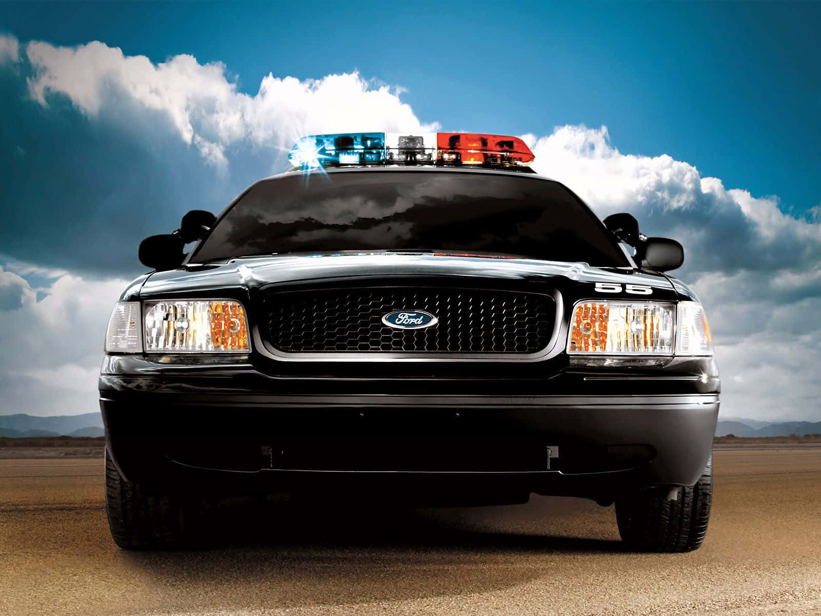 Ford Crown Victoria 桌布 壁紙 — 一輛黑色福特警用SUV，紅藍燈閃爍，在戲劇性的多雲天空下，在沙漠公路上向前行駛。