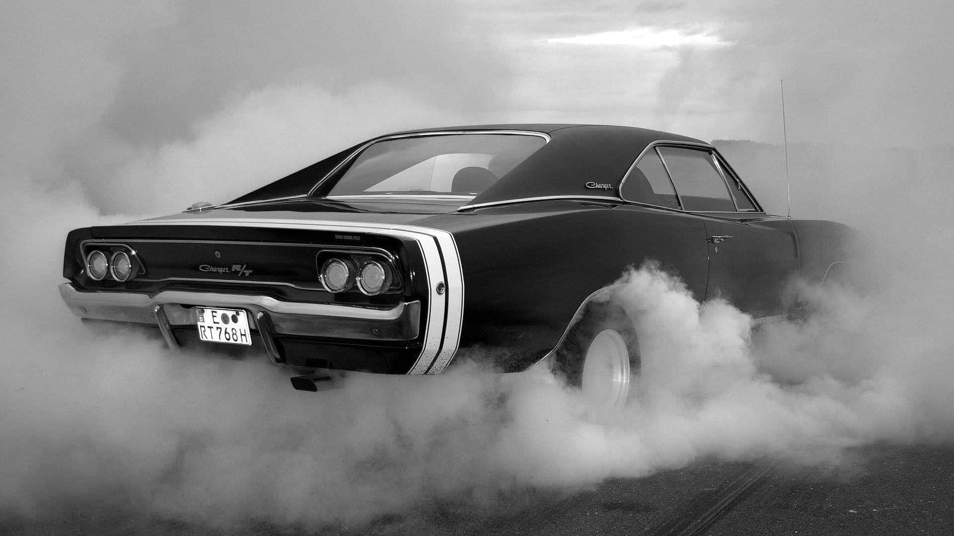Dodge Charger 桌布 壁紙 — 一輛黑色經典肌肉車在陰天背景下，被濃煙包圍進行燒胎表演。