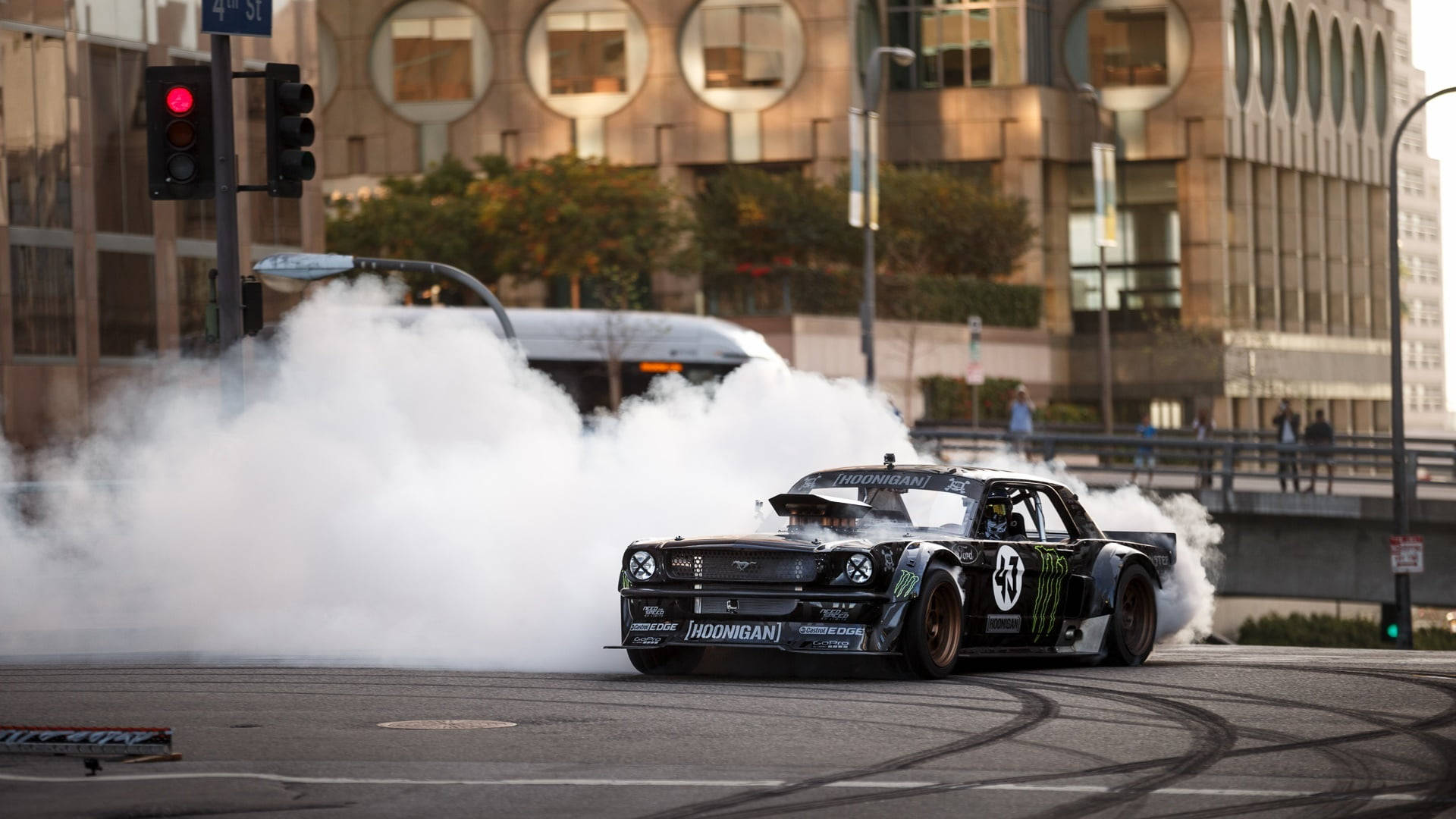 race car 桌布 壁紙 — 一輛黑色飄移車在黃昏時分的城市街道上劃過彎道，冒出濃煙。