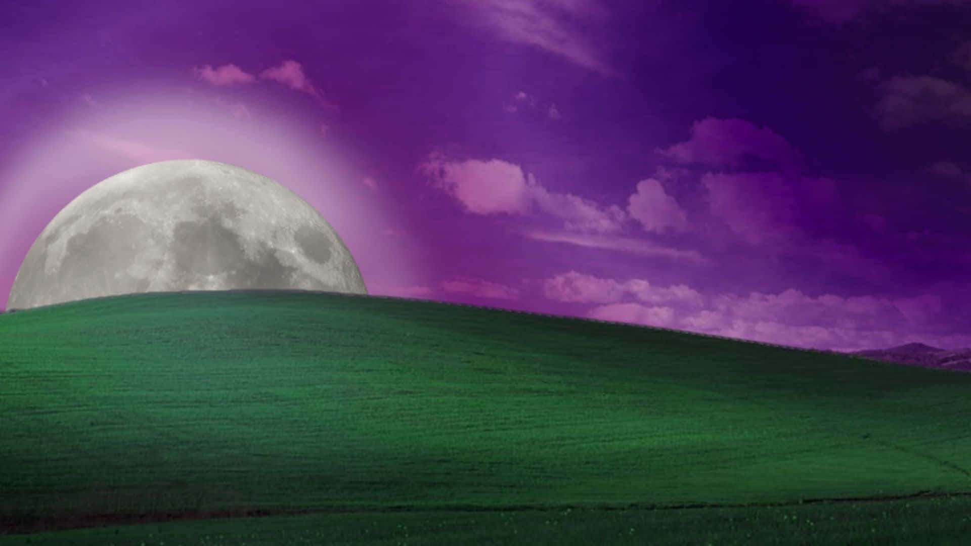 Windows Xp Bliss 桌布 壁紙 — 一輪巨大的月亮在柔軟雲朵點綴的鮮豔紫色天空下，從起伏的綠色山丘上升起。